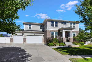 Traditional-style residence featuring a two-story design, a covered entry with columns, and a 3-car garage