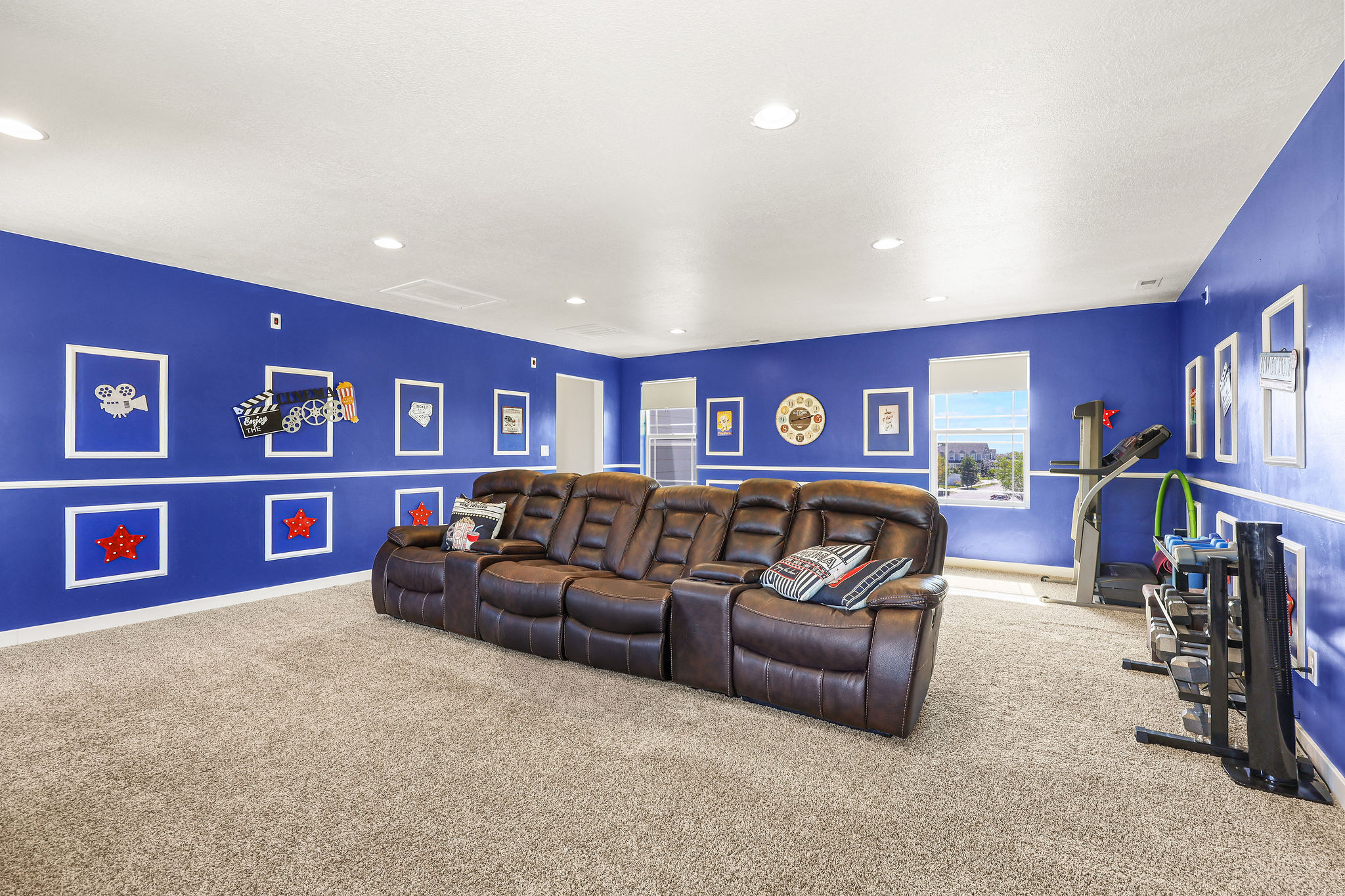 Spacious room featuring broadloom carpeting, recessed lighting, and bright blue walls with white dado rail molding