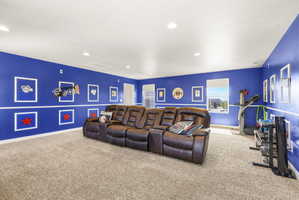 Spacious room featuring broadloom carpeting, recessed lighting, and bright blue walls with white dado rail molding