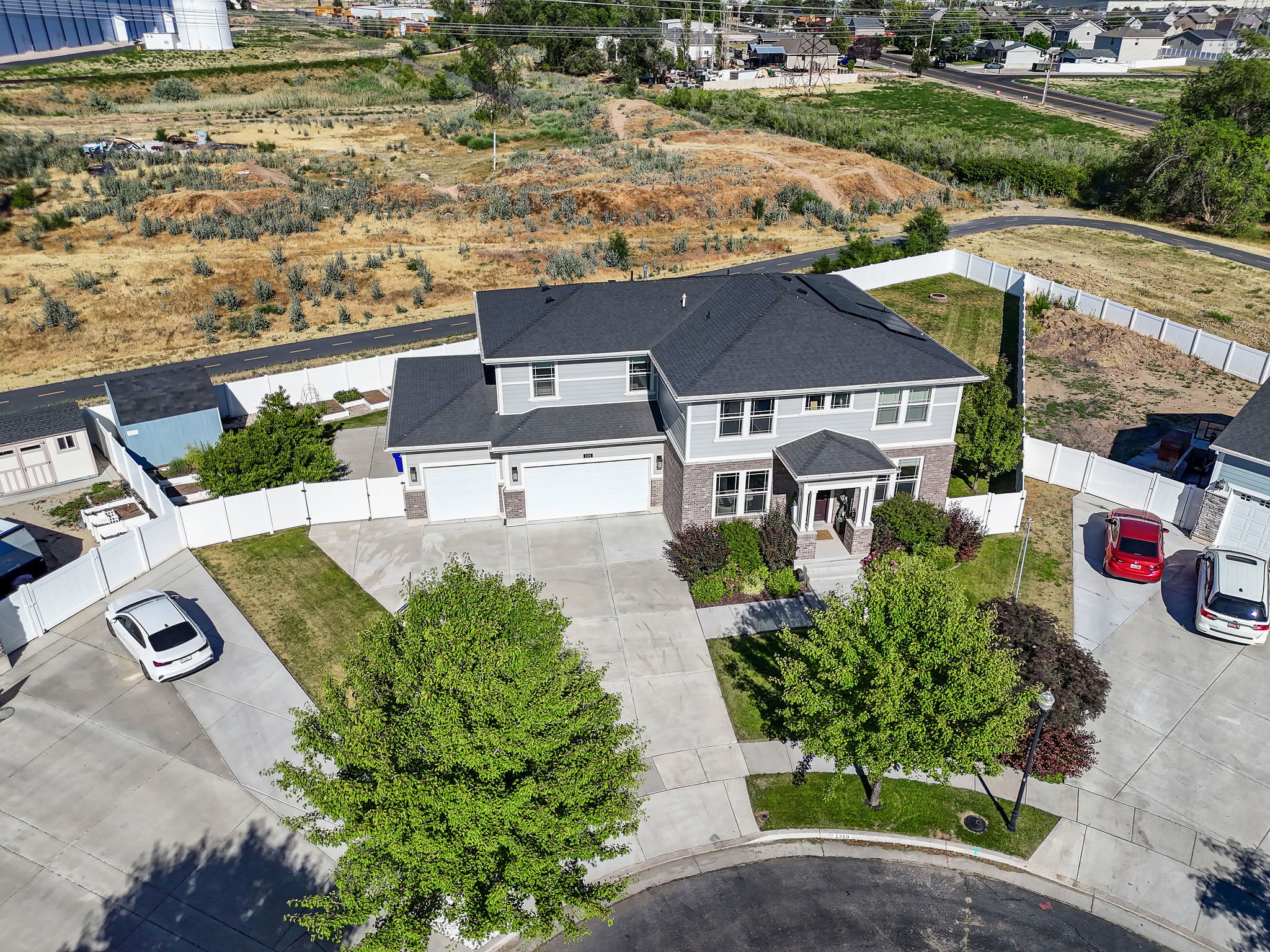 Two-story residence featuring a gray and brick facade with a dark shingle roof