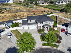 Two-story residence featuring a gray and brick facade with a dark shingle roof
