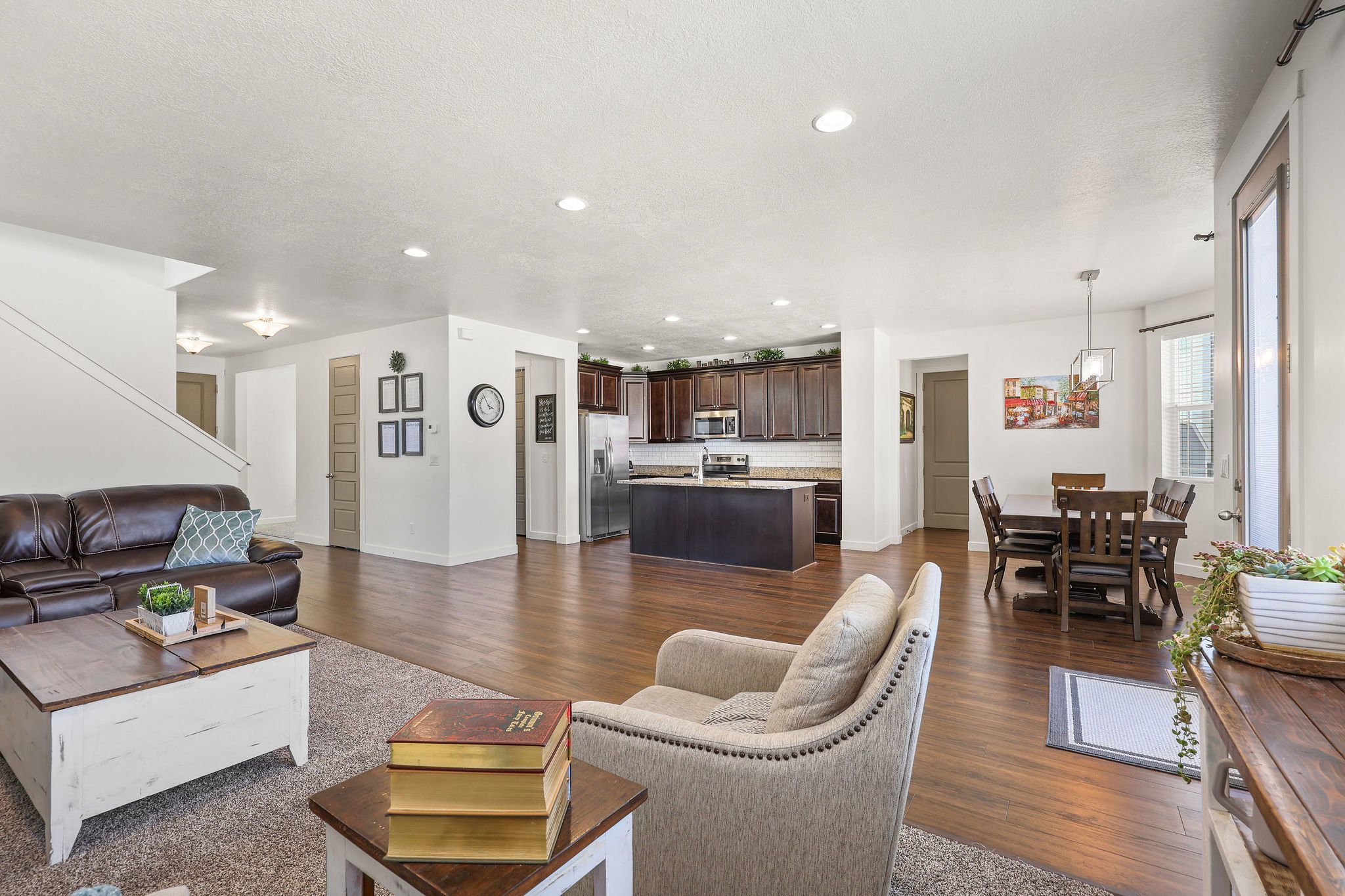 Open-concept living area featuring wood-finish flooring, recessed lighting, and a neutral color palette