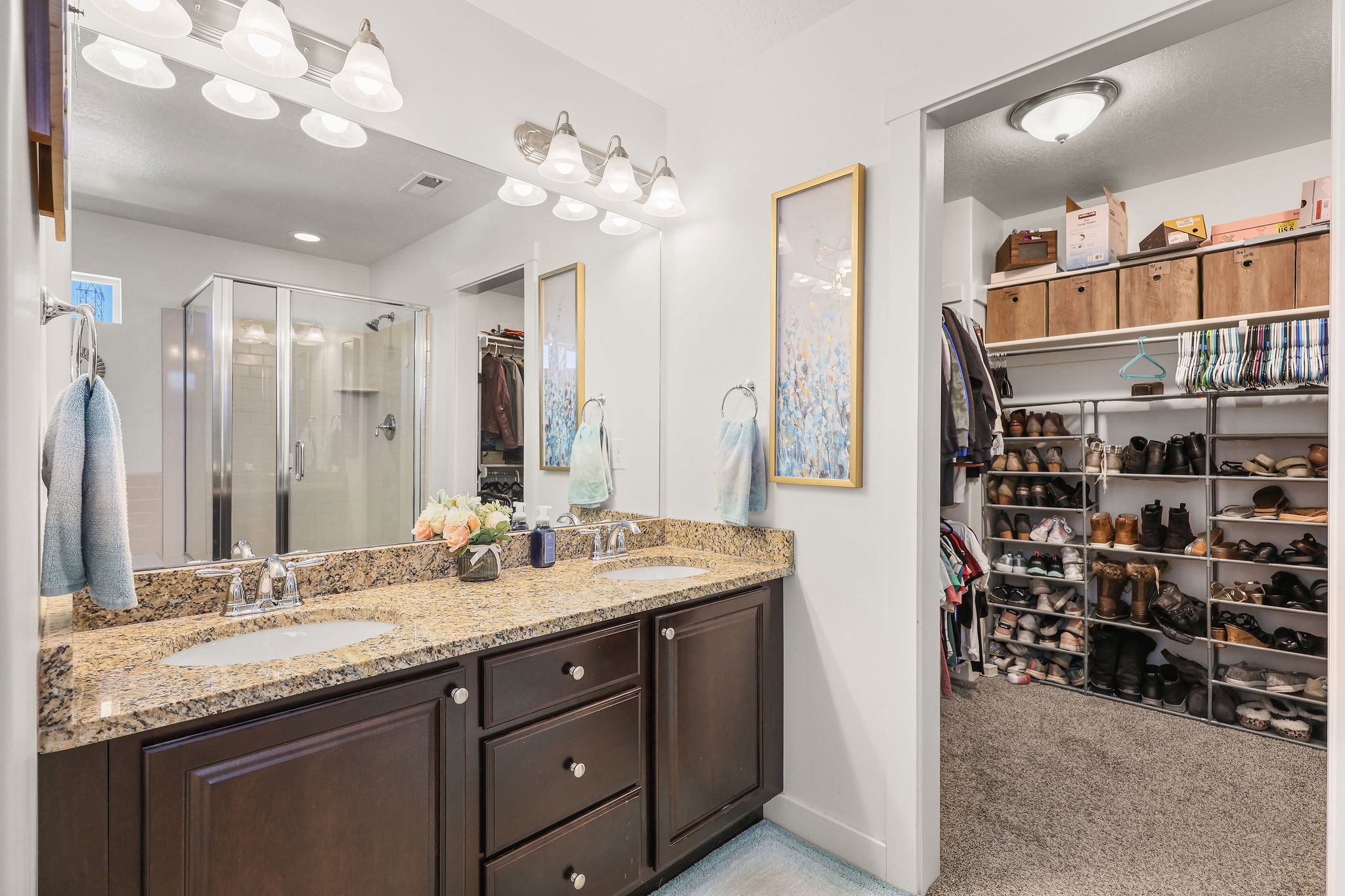 Bathroom featuring a double vanity with granite countertop and dark wood cabinetry