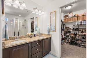 Bathroom featuring a double vanity with granite countertop and dark wood cabinetry