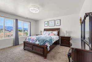 Expansive windows showcasing mountain scenery, complemented by plush carpet flooring, a contemporary ceiling light fixture, and white wall finishes