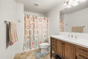 Bathroom featuring a wood-finish vanity with a white countertop, an integrated sink, and a chrome faucet