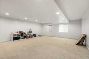 Spacious room featuring neutral carpeting, recessed lighting, white walls, and two windows with blinds