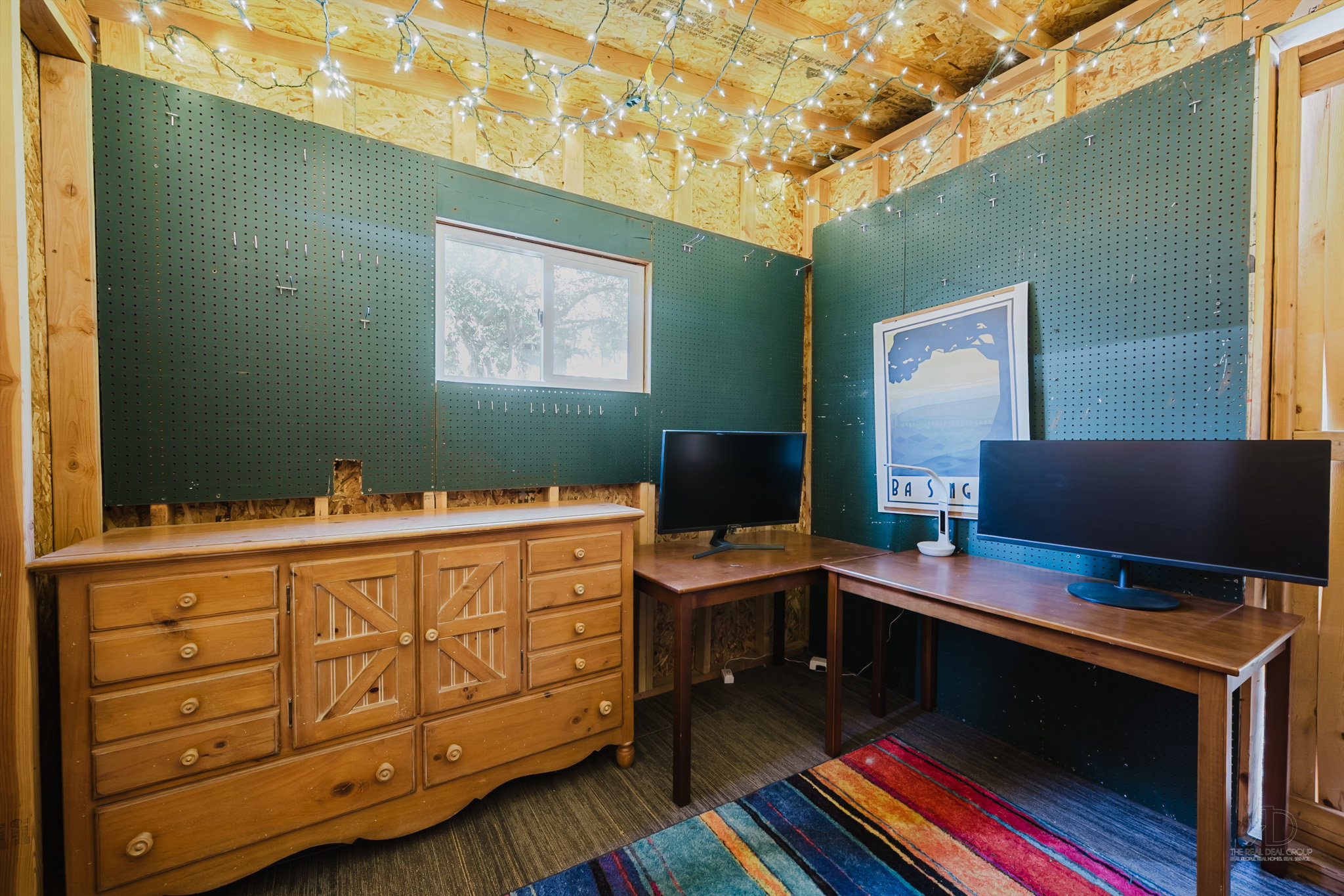 Interior space featuring exposed wood-finish structural elements and dark green pegboard walls