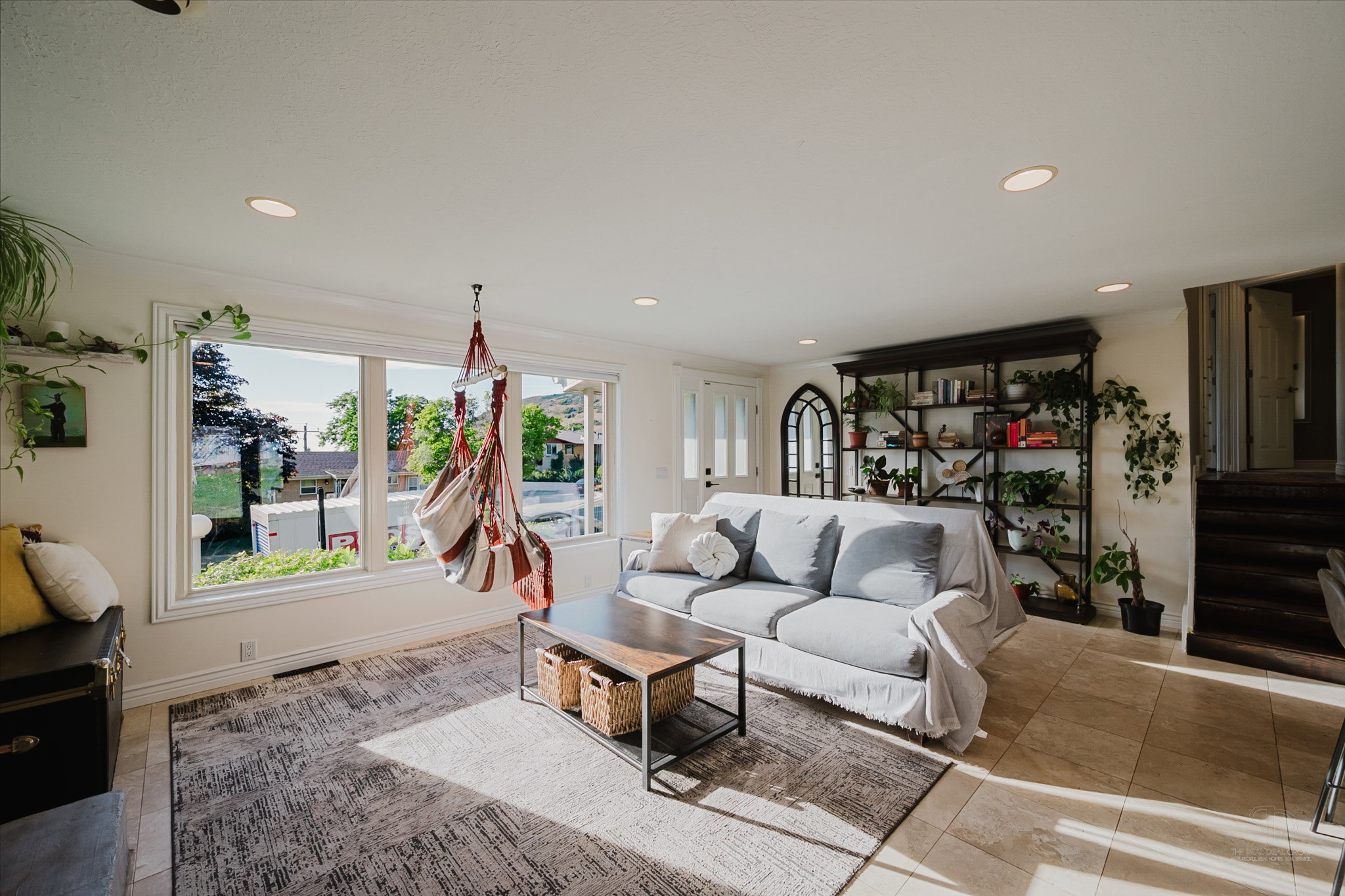 Living area featuring large windows, recessed lighting, and a built-in shelving unit