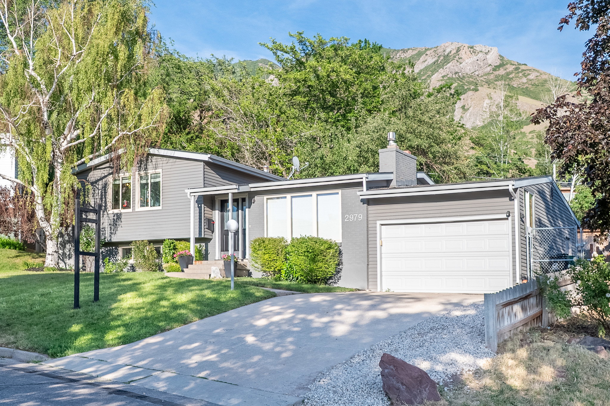 Split-level residence featuring a gray exterior and white trim
