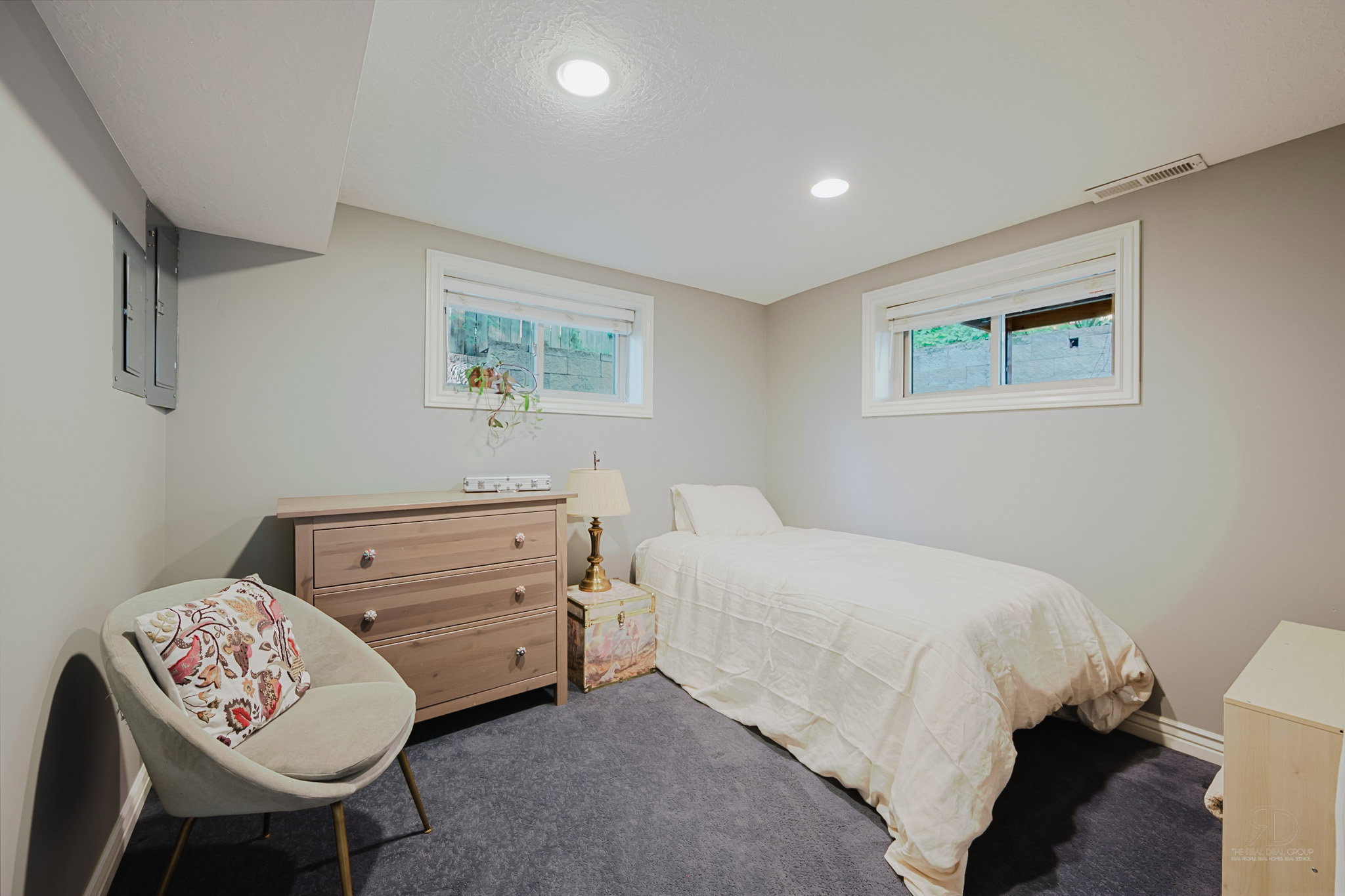 Carpeted room with two egress windows featuring white trim