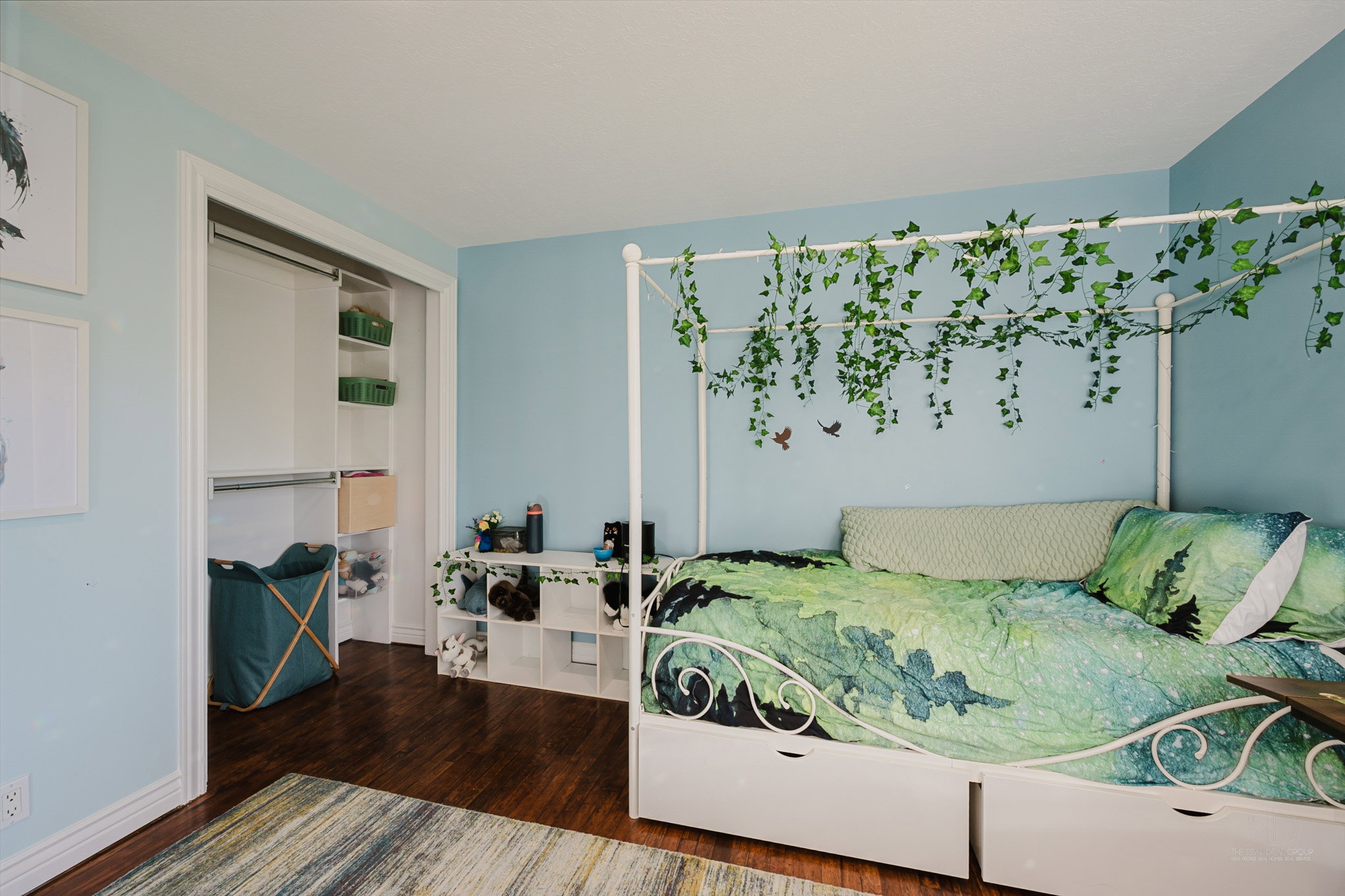 Bedroom featuring wood-finish flooring and a built-in closet organization system