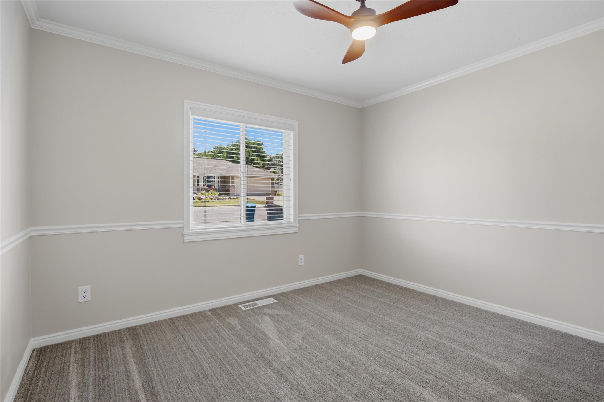 Interior room featuring crown molding, chair rail molding, and grey patterned carpeting