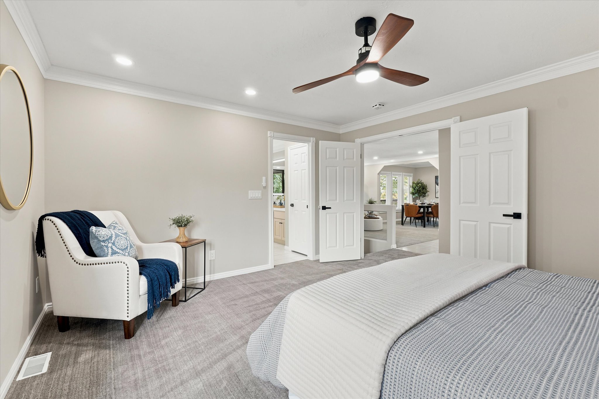 Spacious bedroom with light gray wall paint, recessed lighting, and a contemporary ceiling fan