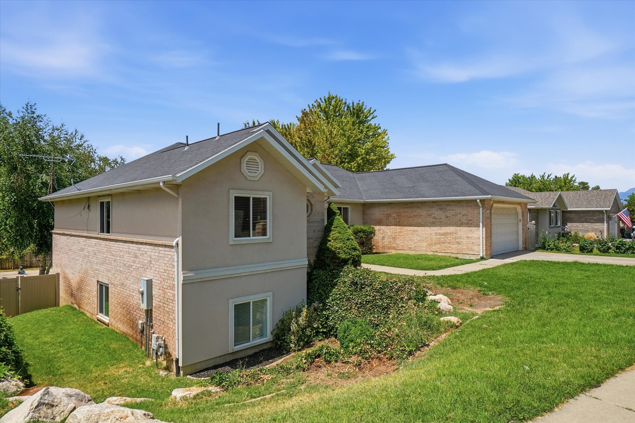 Two-story residence featuring light stucco and brick veneer siding
