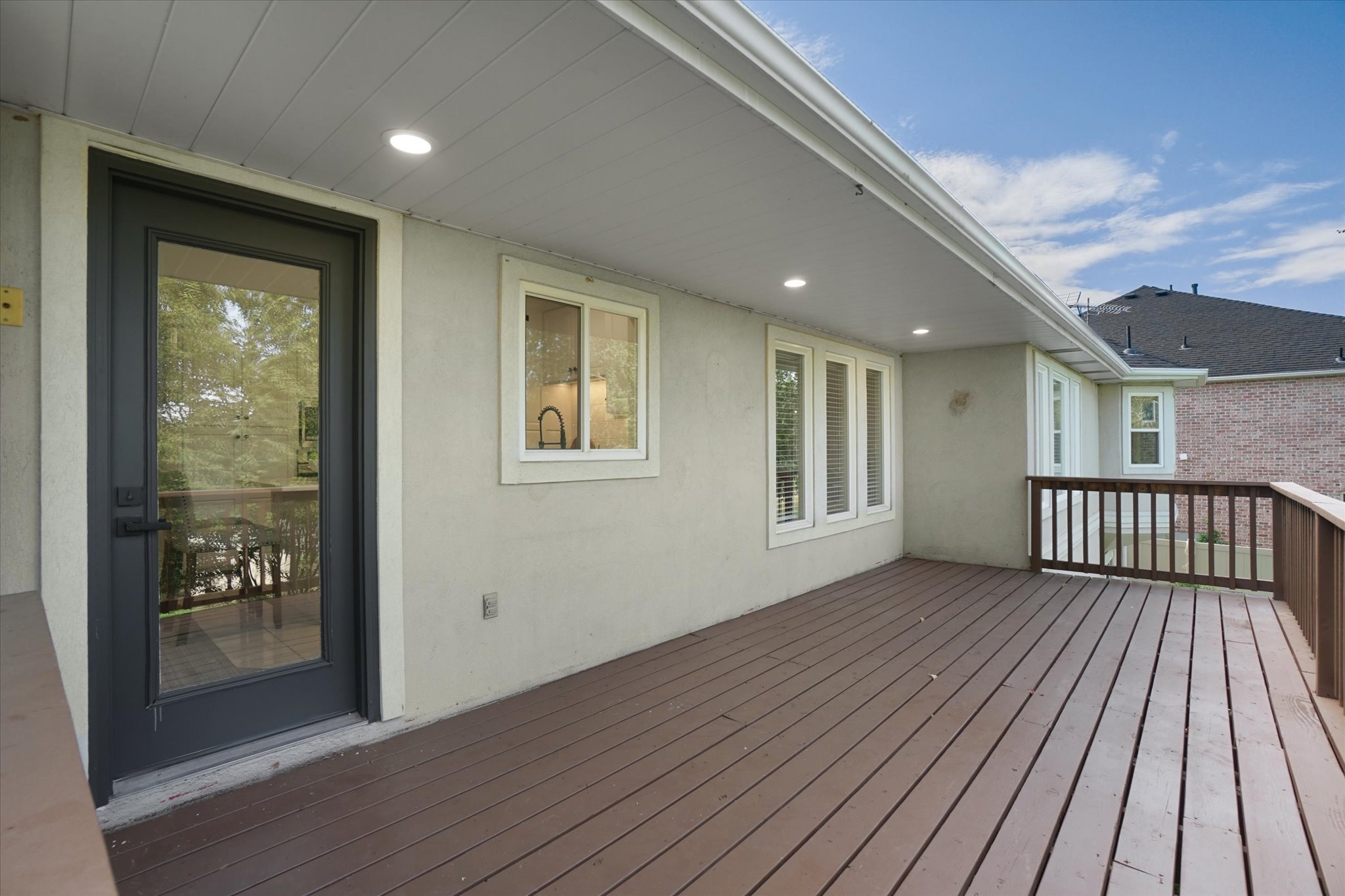 Expansive outdoor deck featuring wood-finish flooring and a wood railing