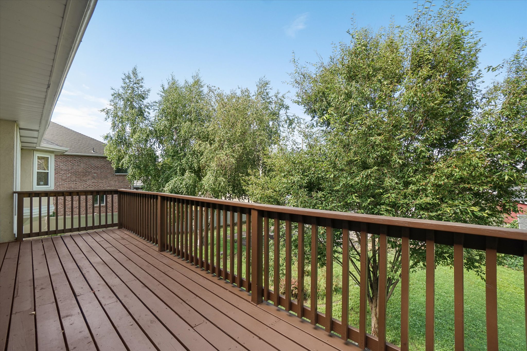 Spacious outdoor deck featuring wood-finish flooring and railing