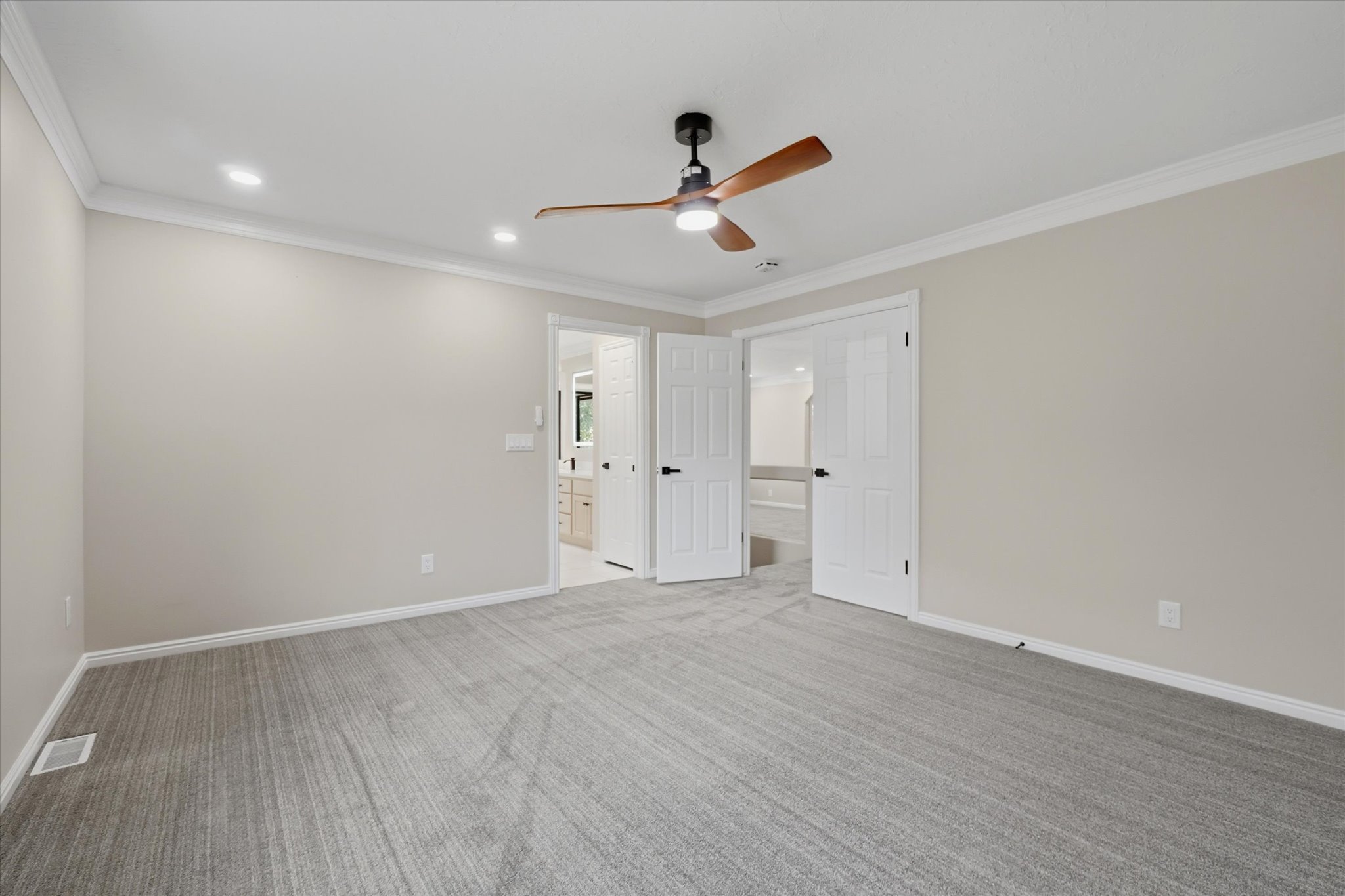 Spacious room featuring neutral carpeting, recessed lighting, and a contemporary ceiling fan