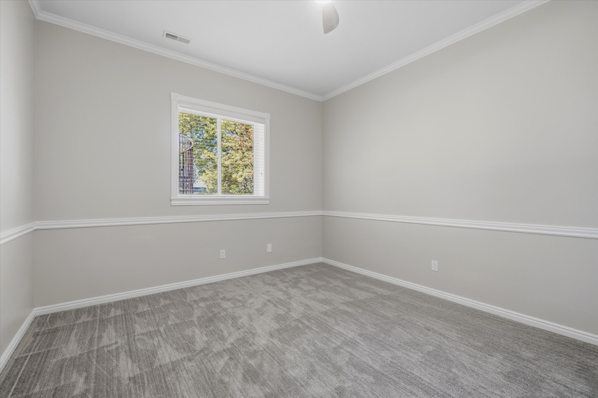 Carpeted room featuring a single window, white trim throughout, and a neutral wall color