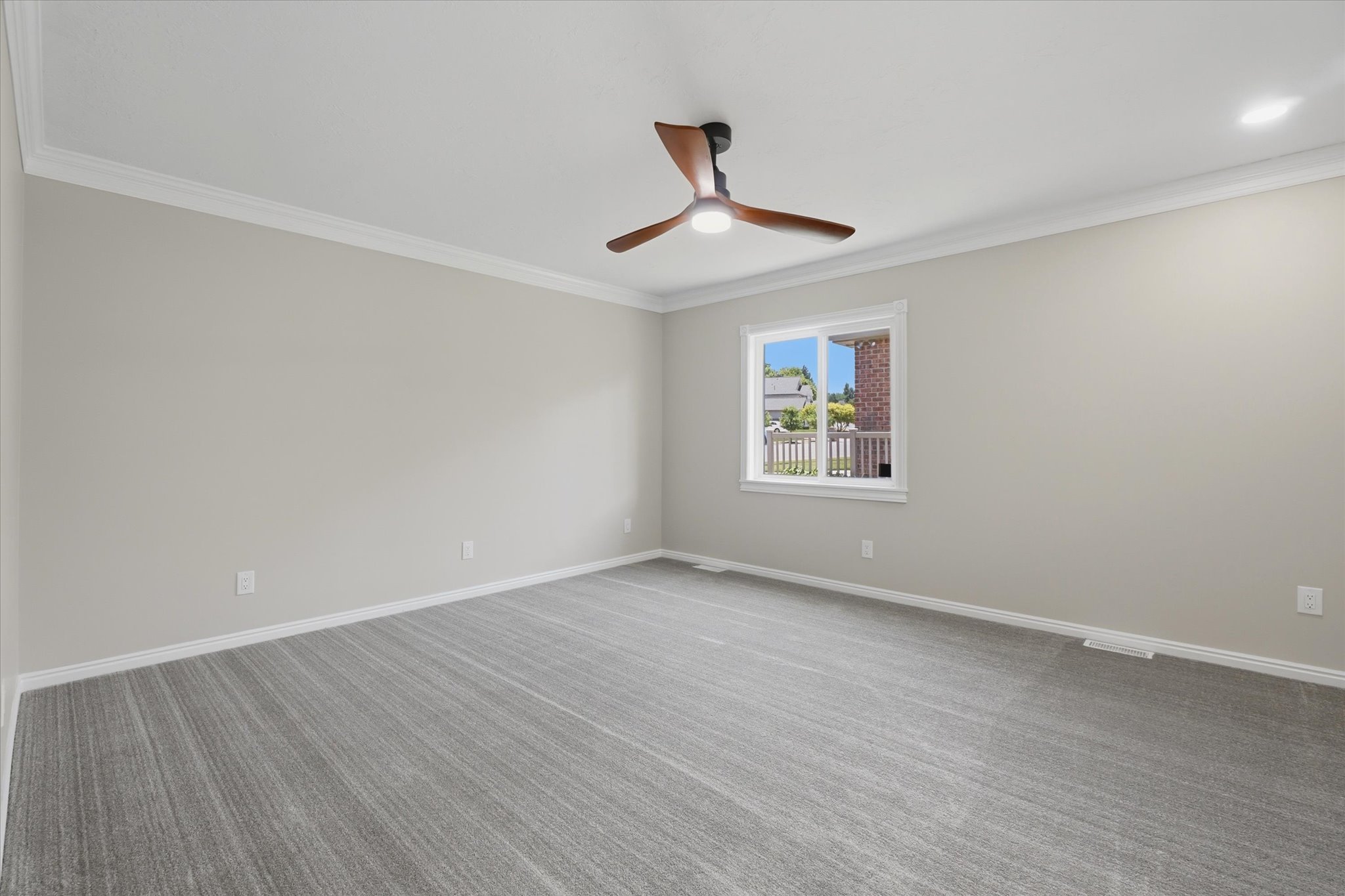 Spacious room featuring gray carpeting, light gray wall paint, and white trim molding