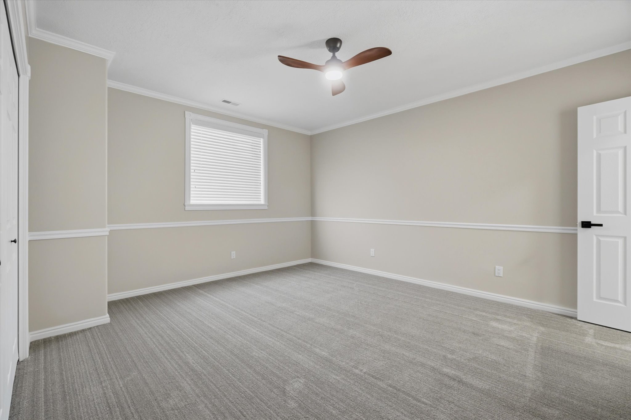 Neutral-toned walls featuring white chair rail molding and baseboards