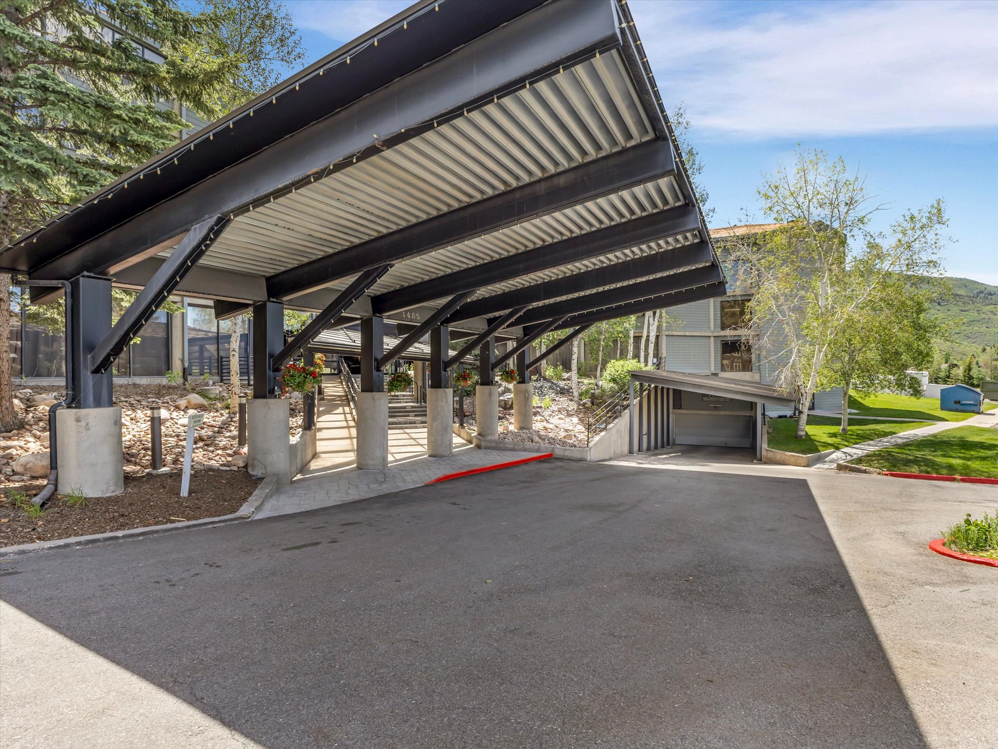 Covered entryway with robust structural beams and concrete columns