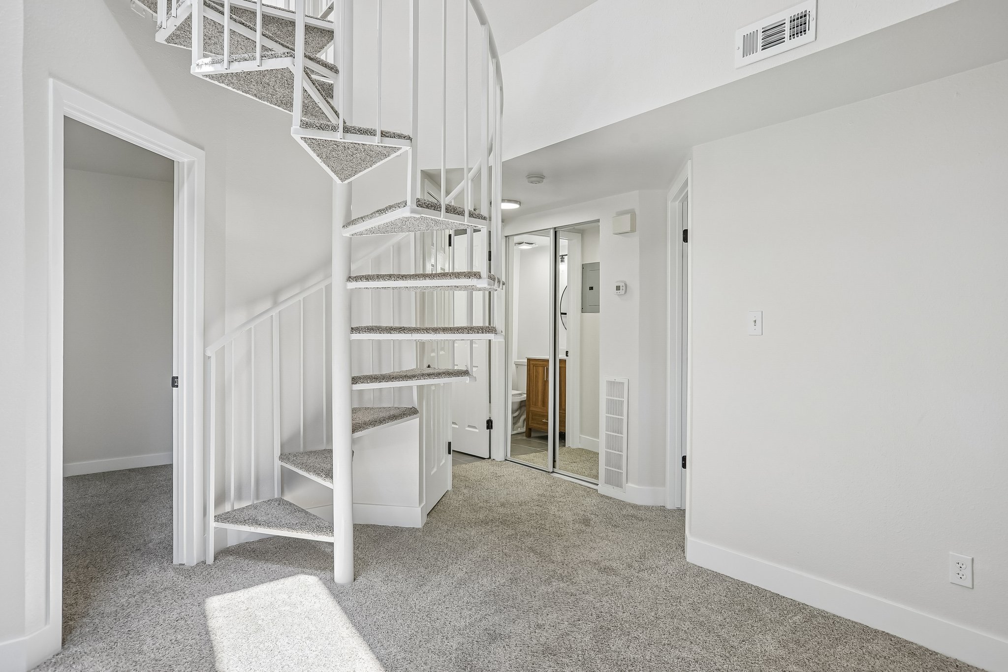 White spiral staircase with carpeted treads
