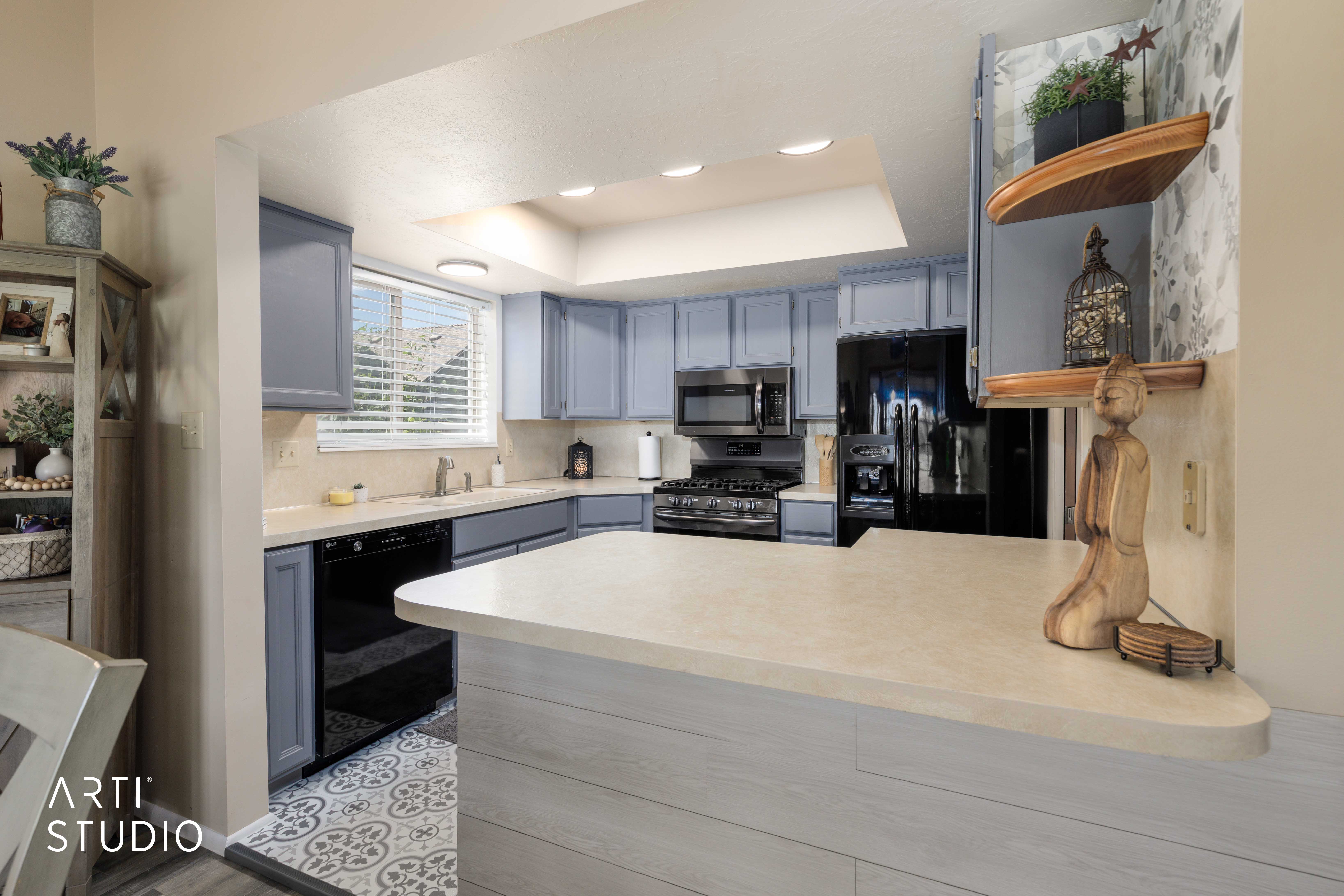 Kitchen with light blue cabinetry, light countertops, black appliances, recessed lighting, and patterned floor tiling