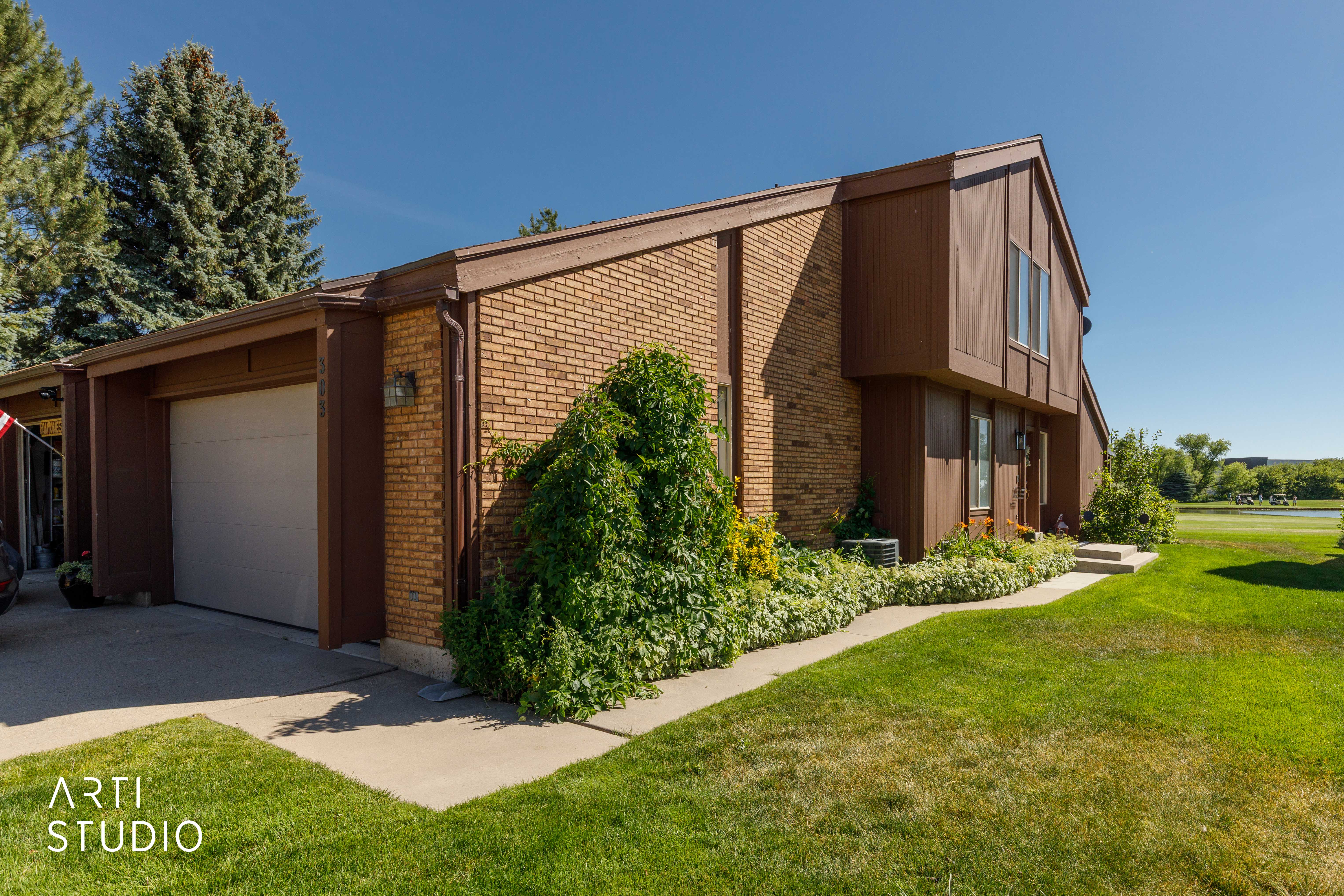 Exterior featuring light brown brick and brown vertical siding