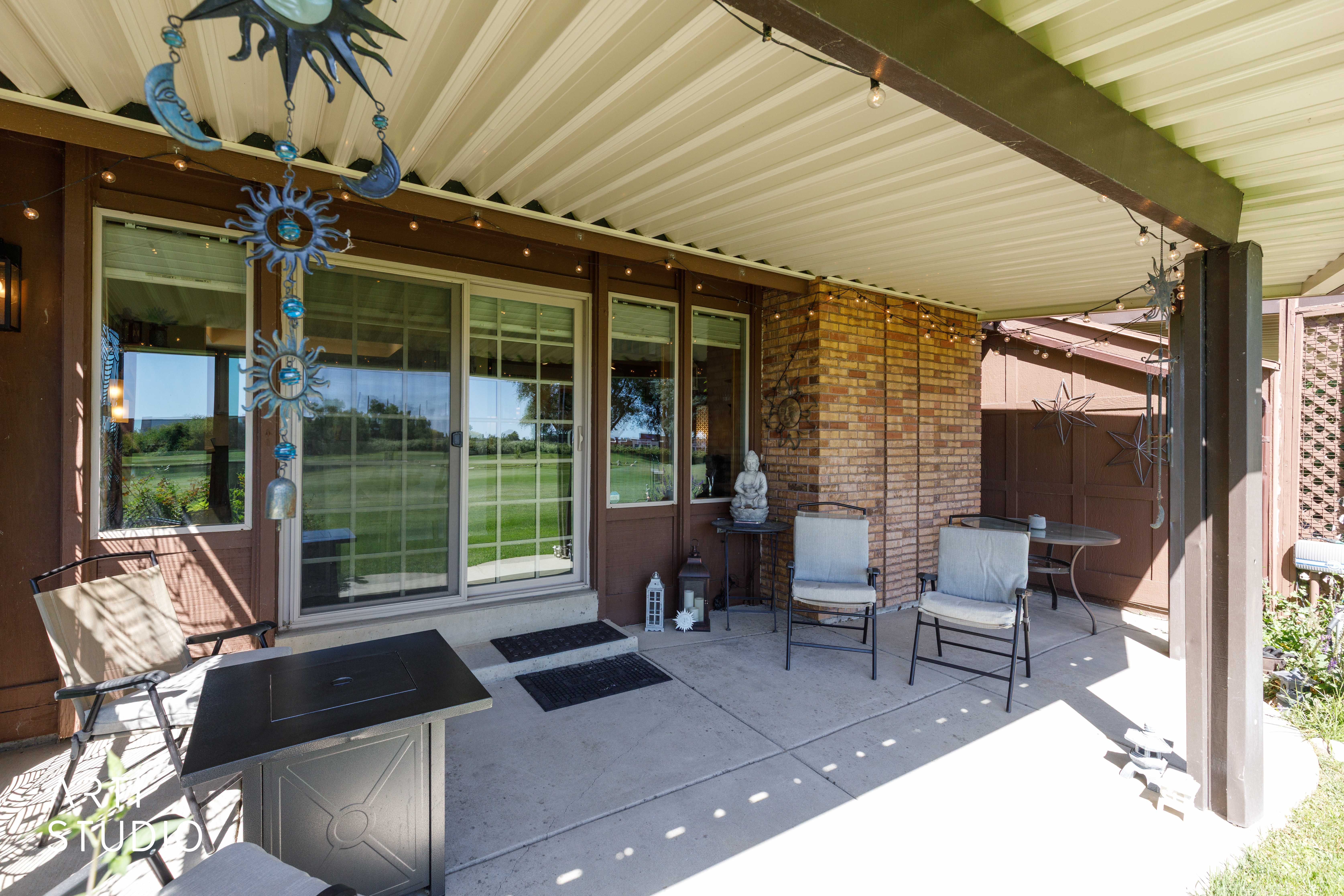Covered patio featuring a concrete slab, a brick exterior wall, and direct access to an outdoor area through a sliding glass door