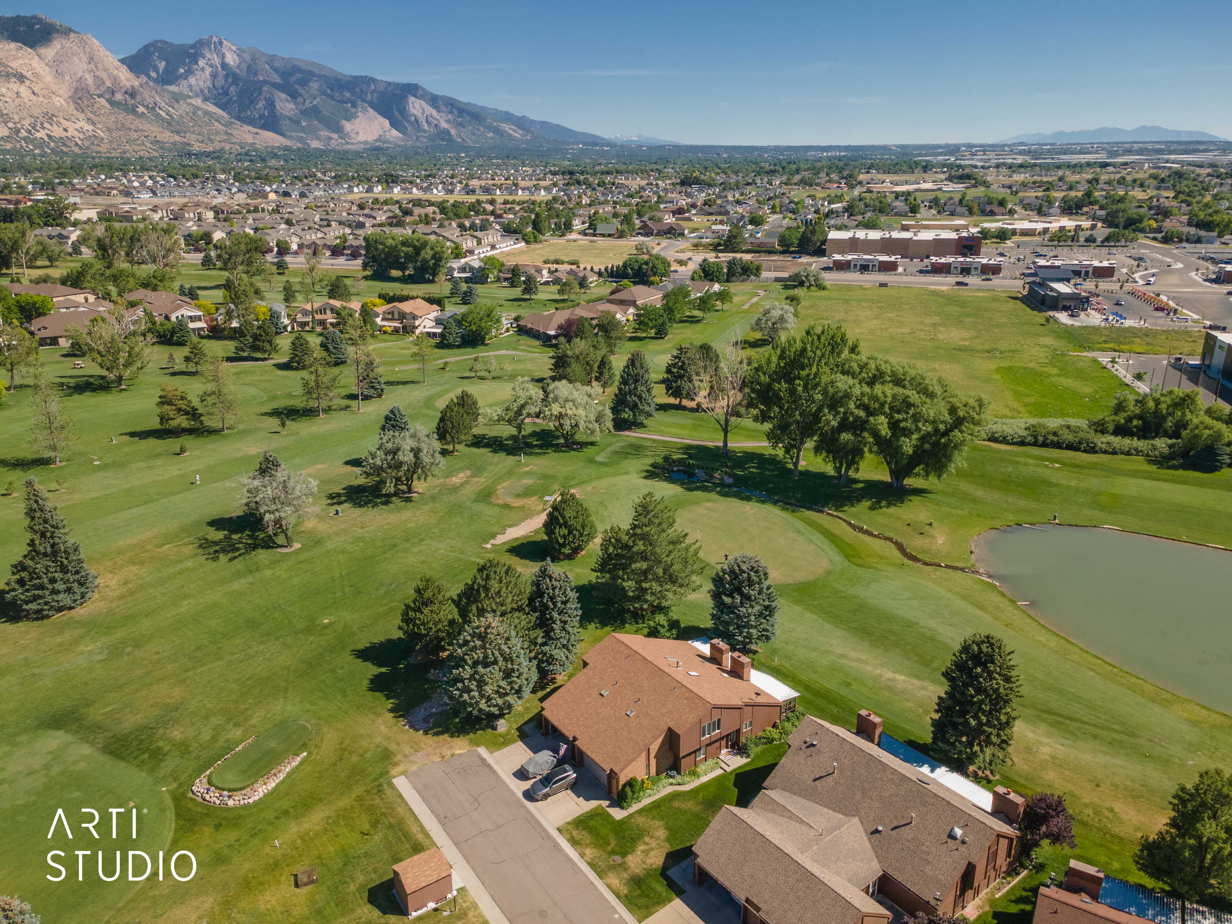 Expansive golf course setting featuring manicured greens and mature trees