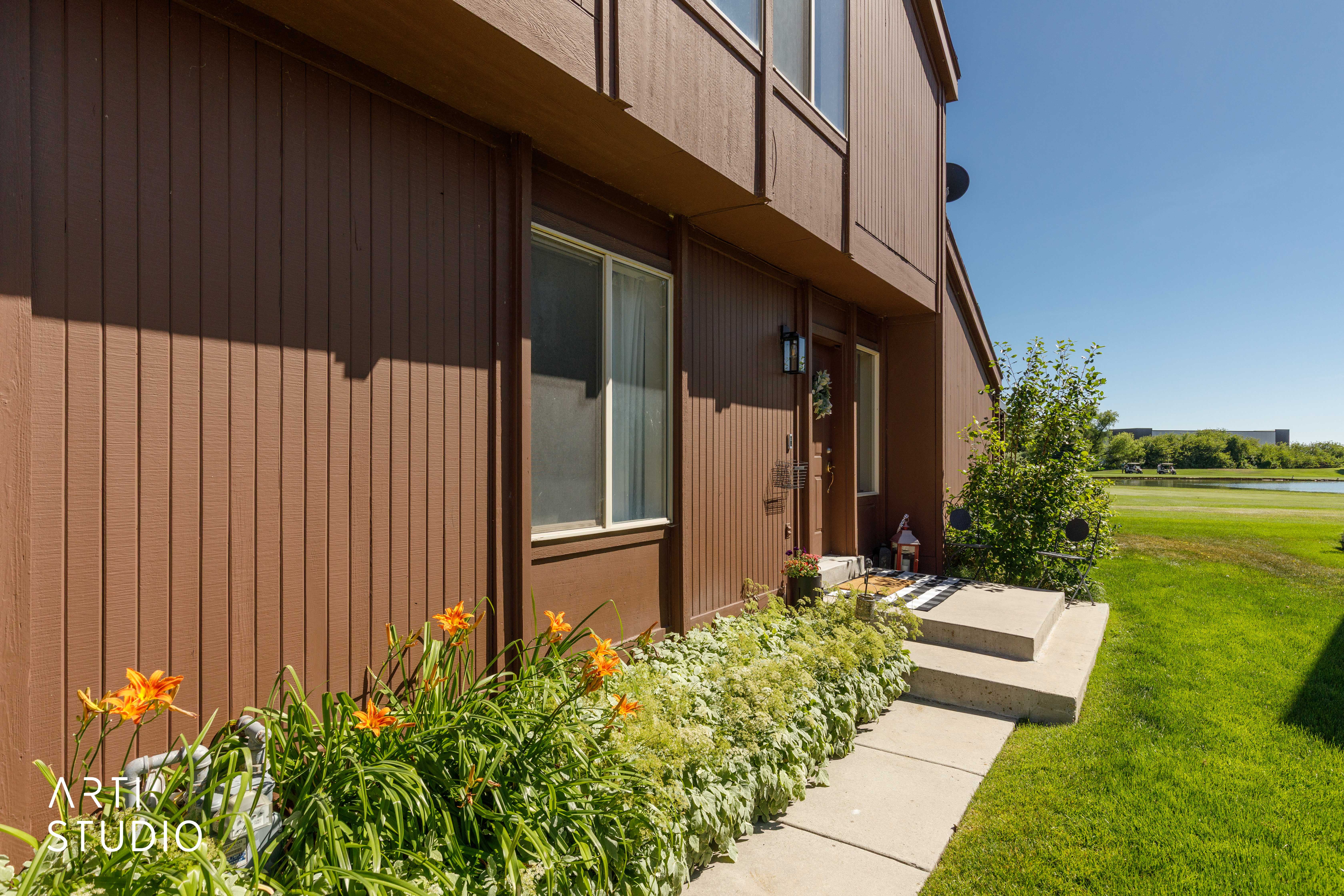 Brown vertical siding exterior with white window frames