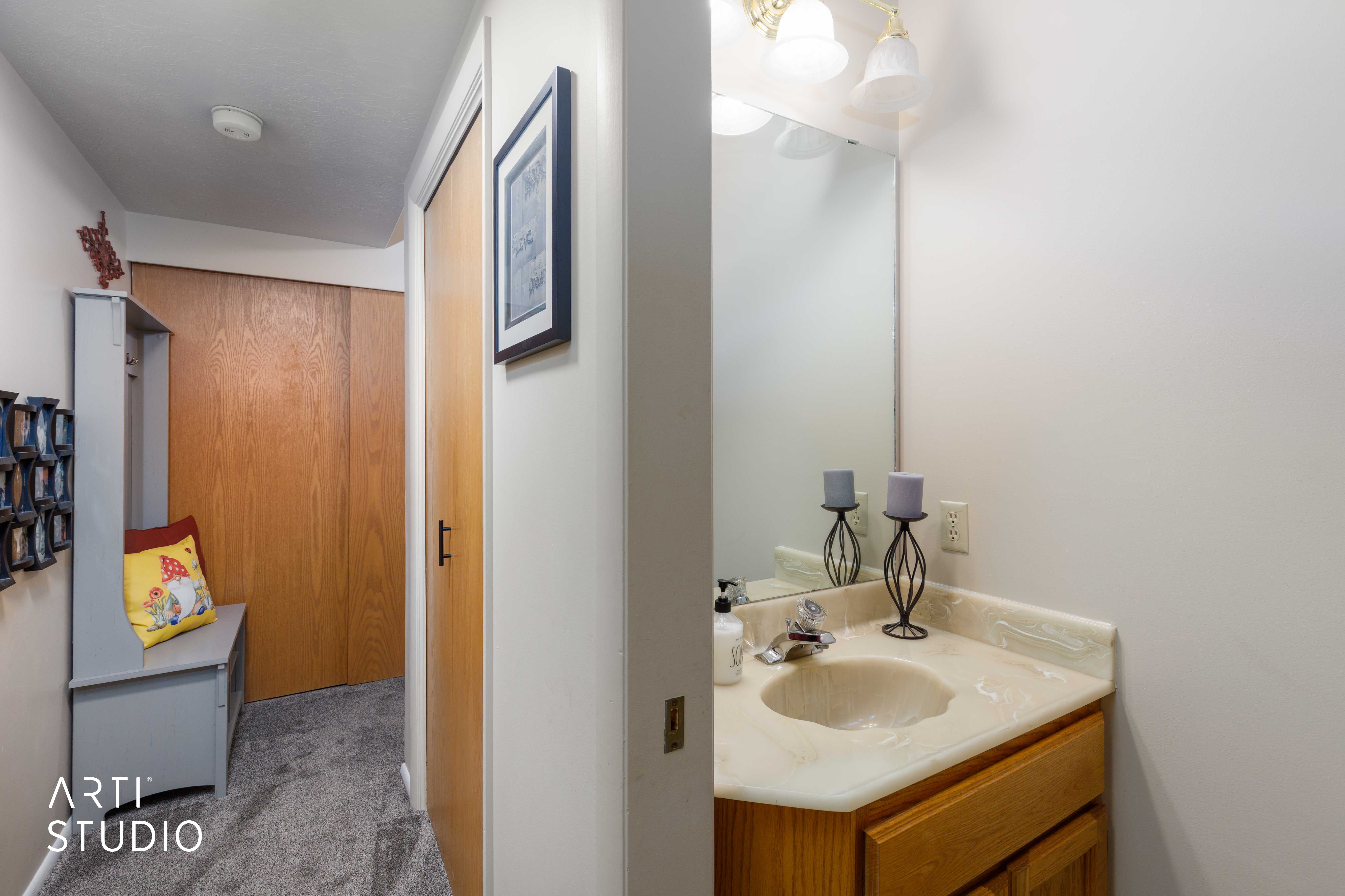 Compact bathroom vanity with a light-toned countertop and wood-finish cabinetry