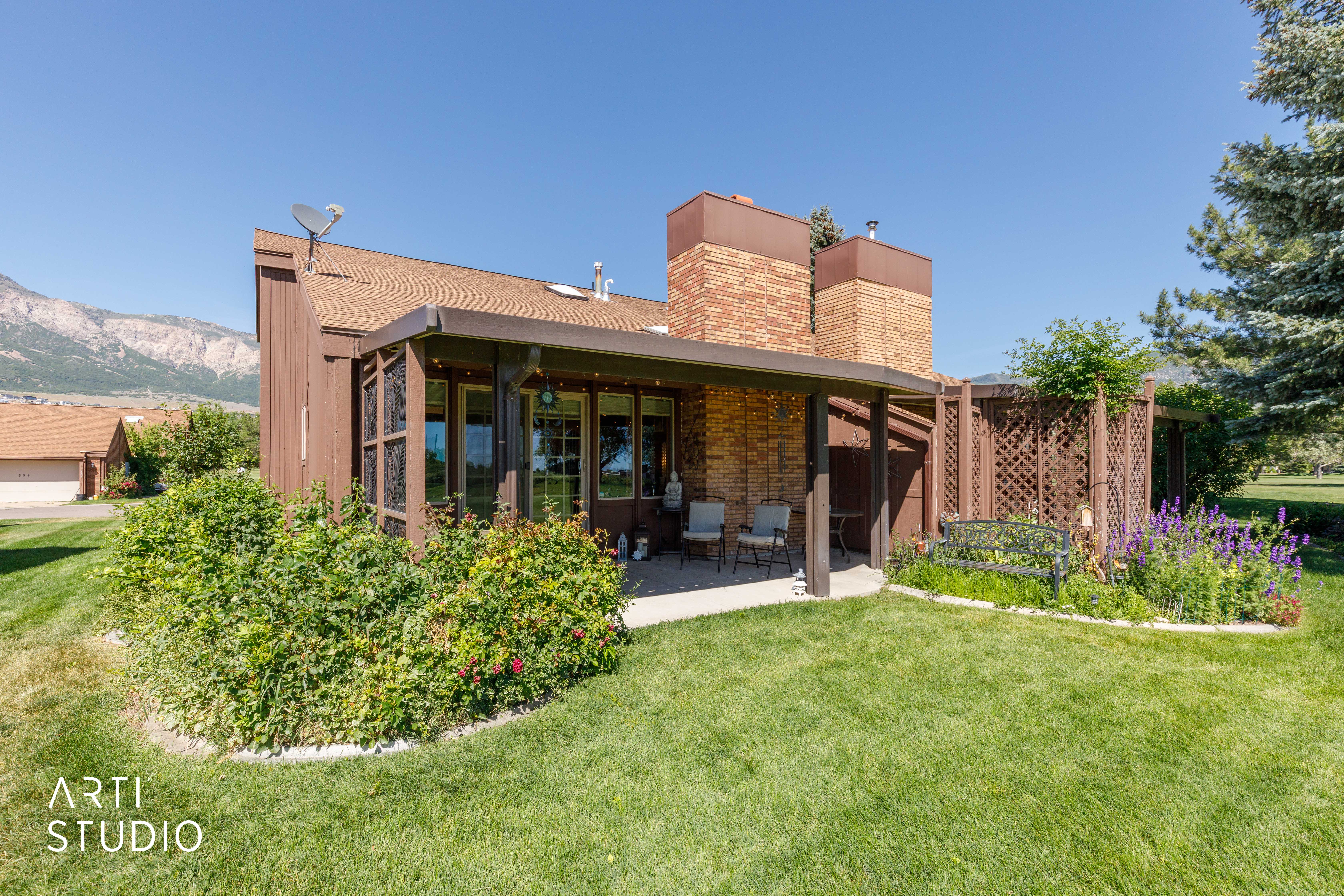 Private patio with a covered pergola and a brick chimney accent