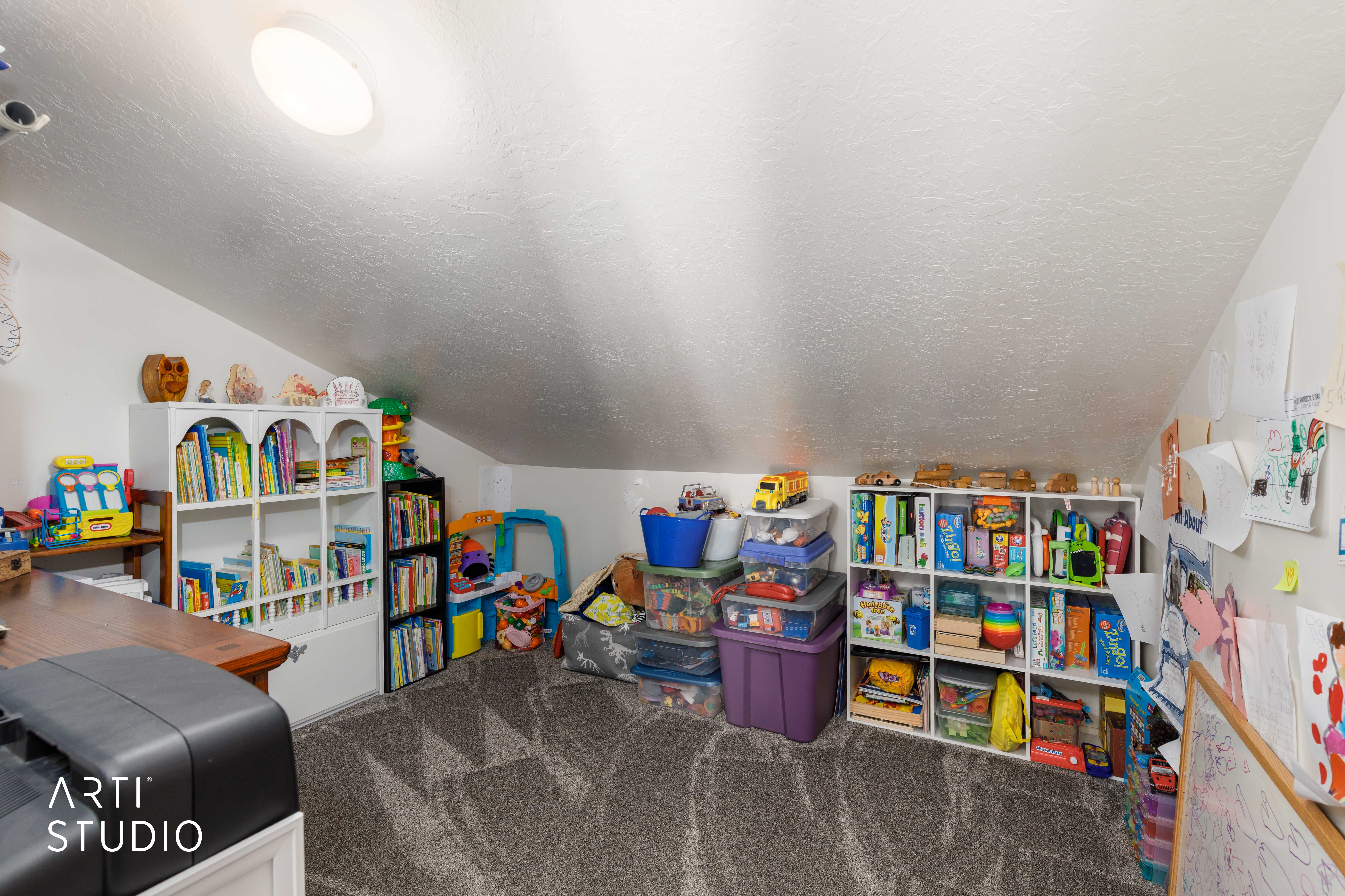 Carpeted room with sloped ceilings and built-in shelving
