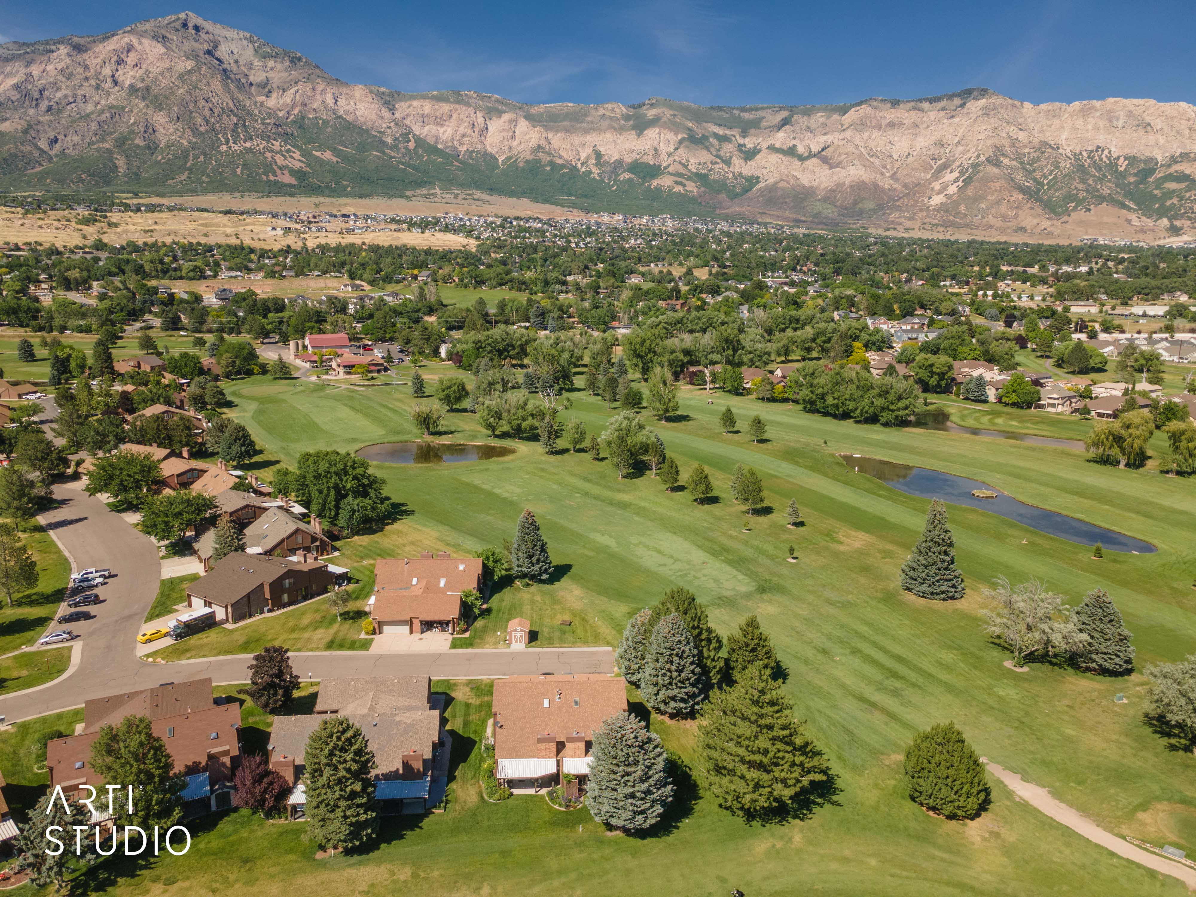 Expansive golf course property featuring green fairways, scattered trees, and two water features