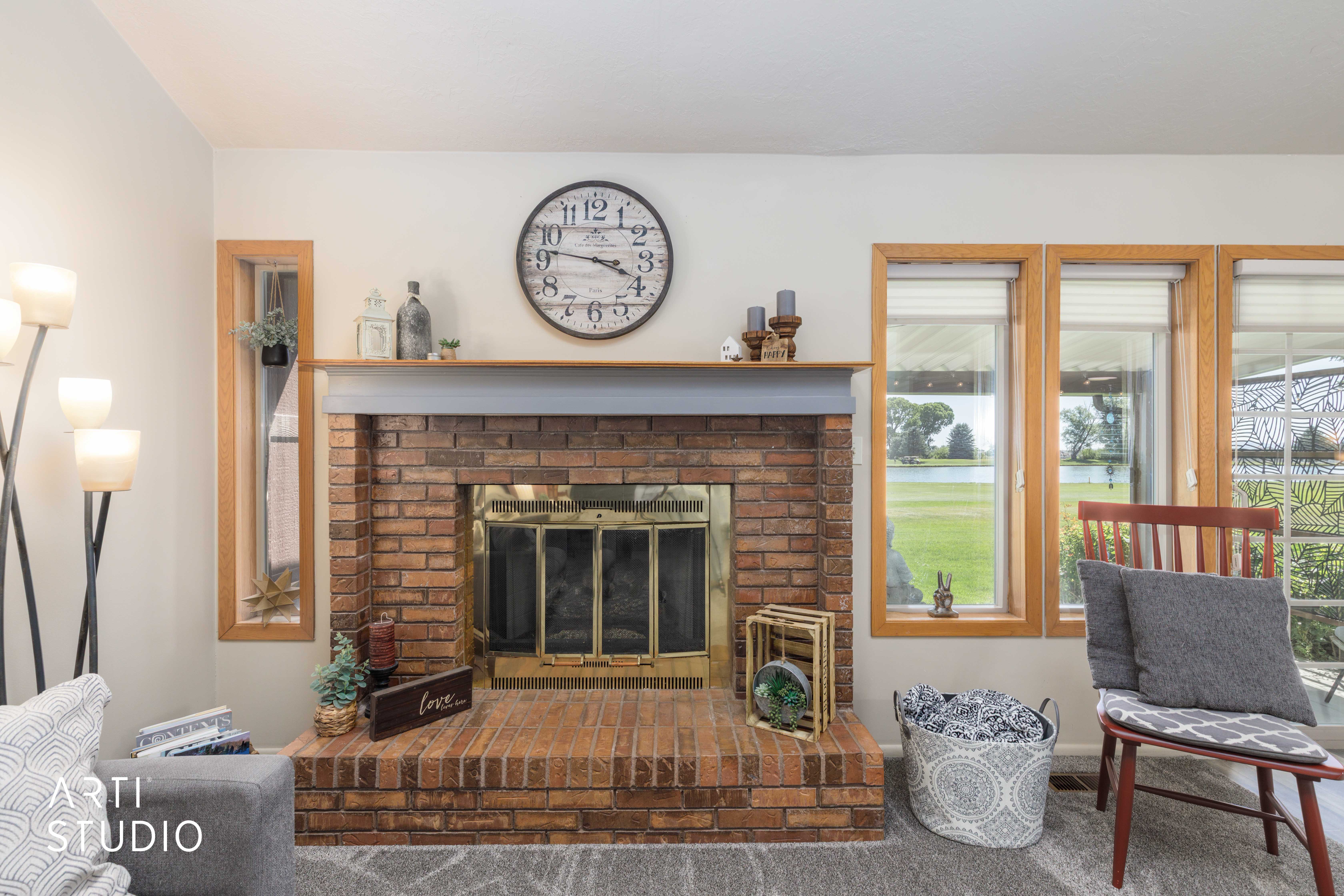 Brick fireplace with brass firebox and wood mantel