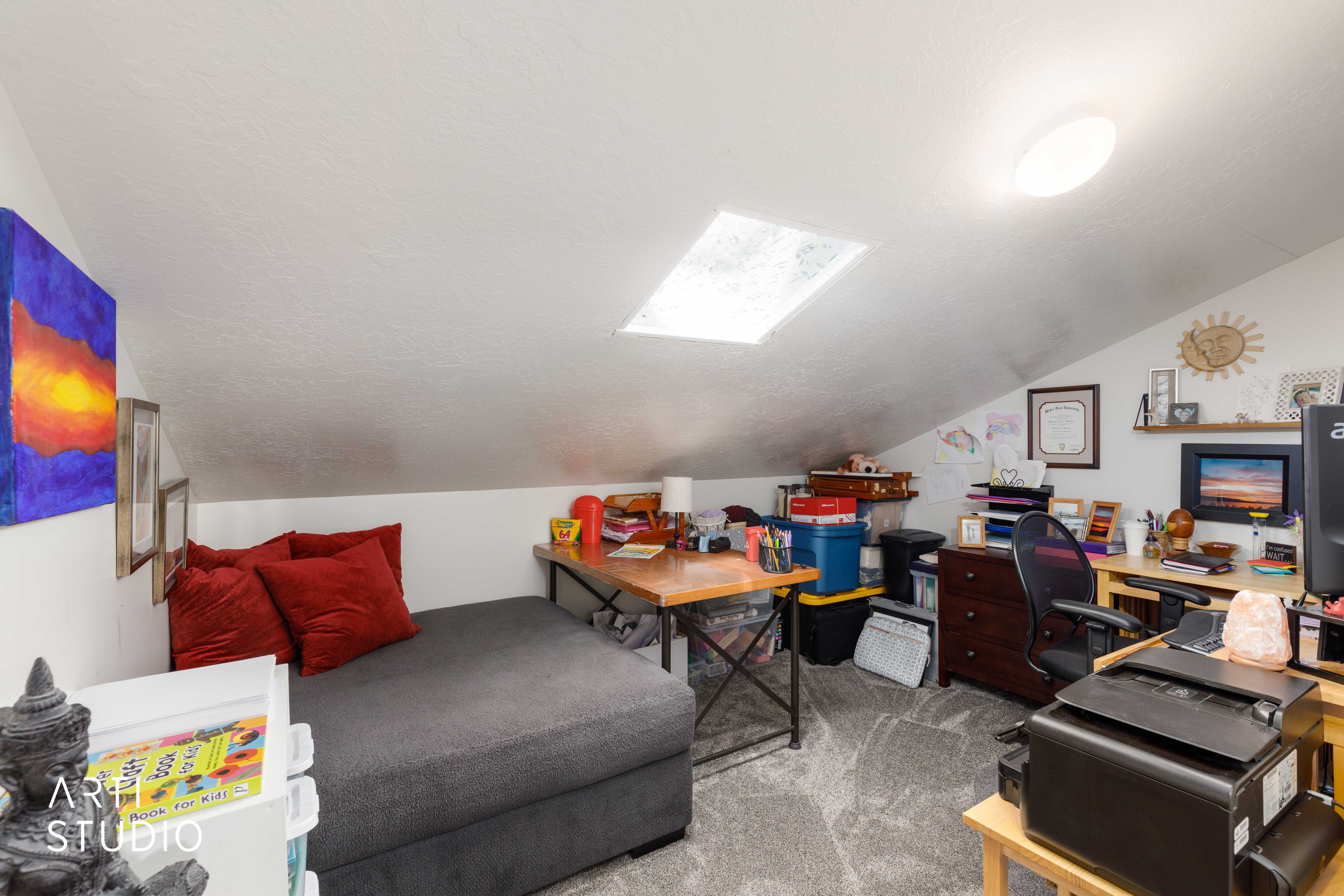 Attic conversion room featuring a skylight and sloped ceilings