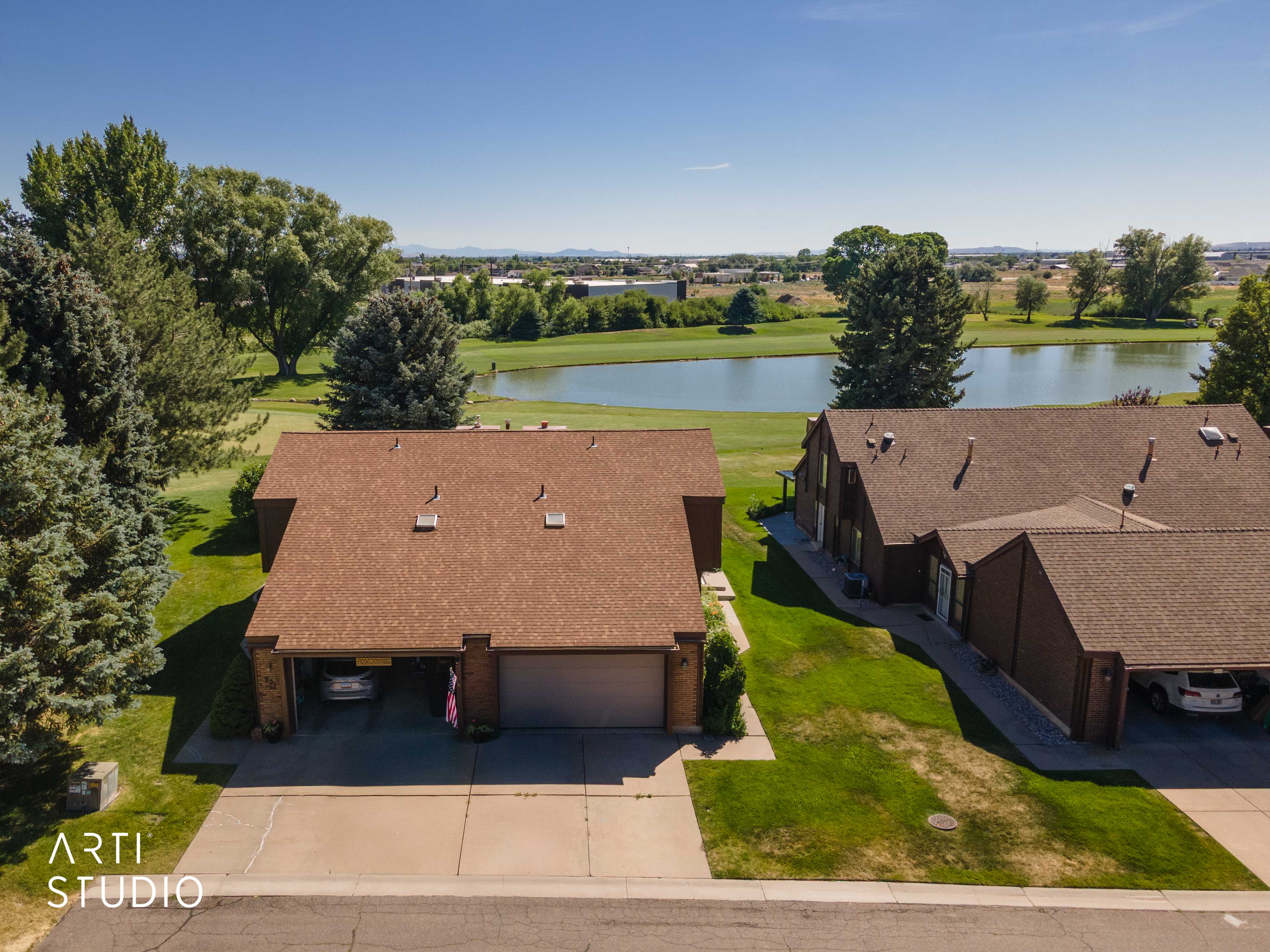 Brown shingle roofing complementing the exterior, concrete driveway, and attached carport