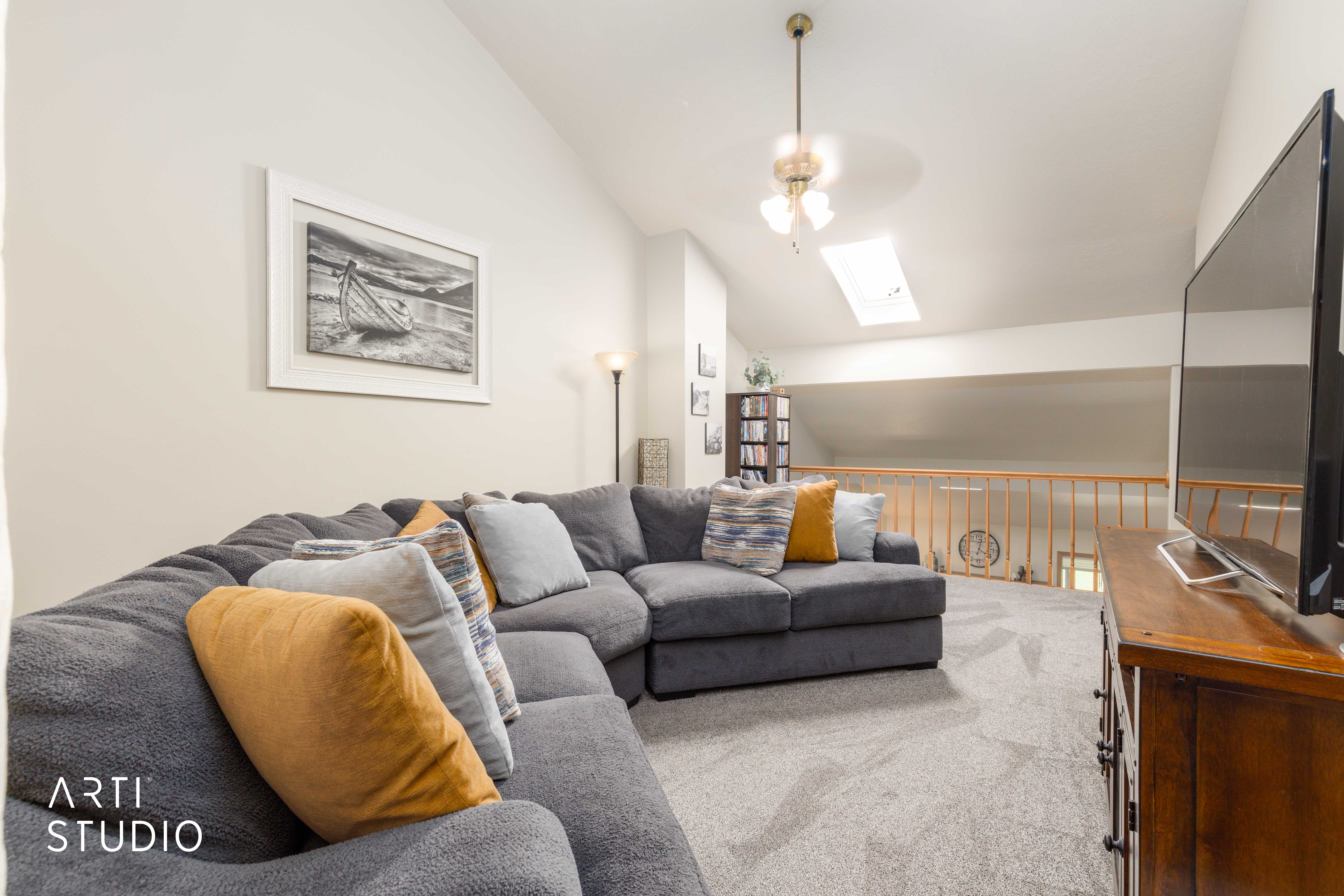 Vaulted ceiling with a central chandelier and skylight
