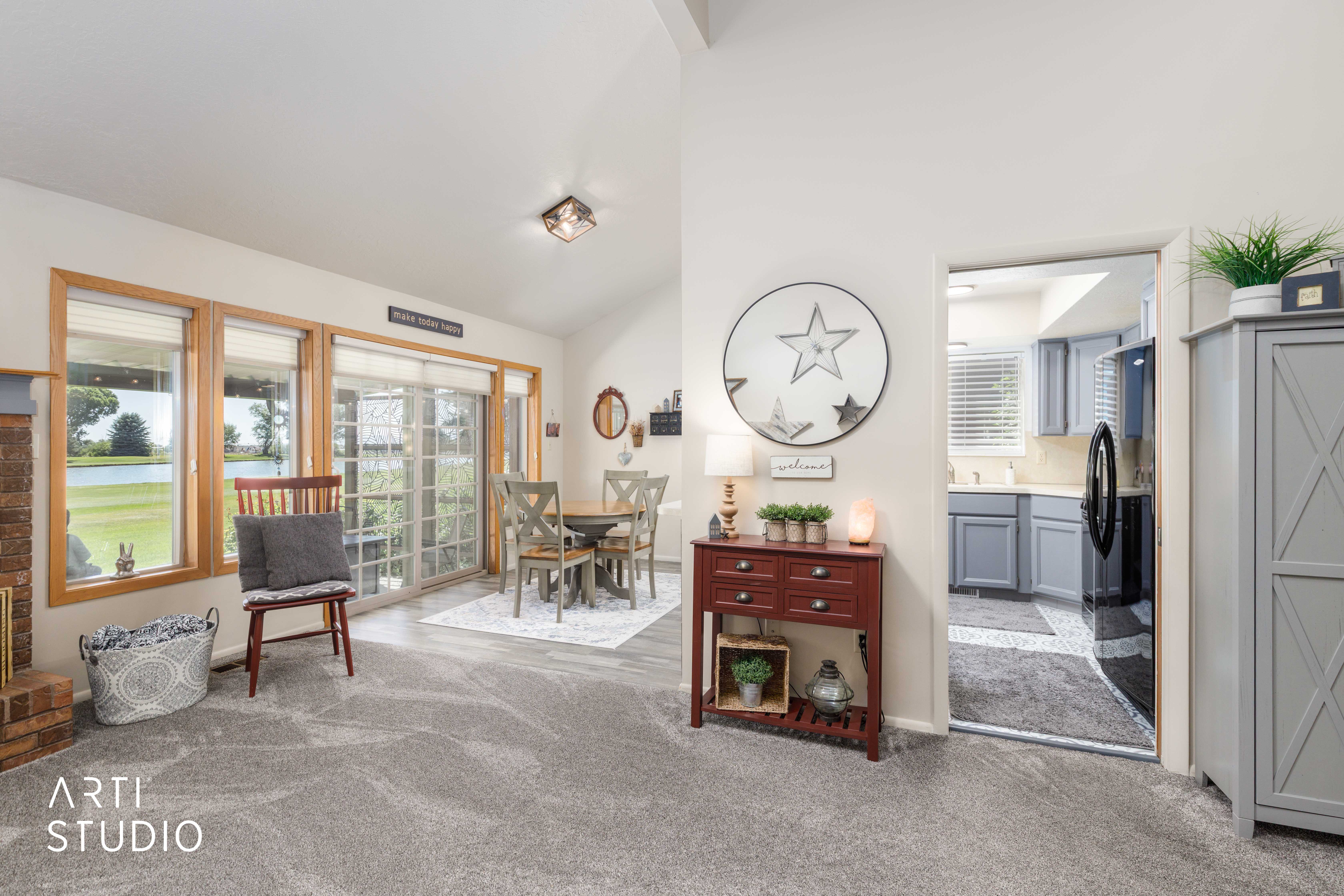 Open concept living area featuring vaulted ceilings and light gray carpeting
