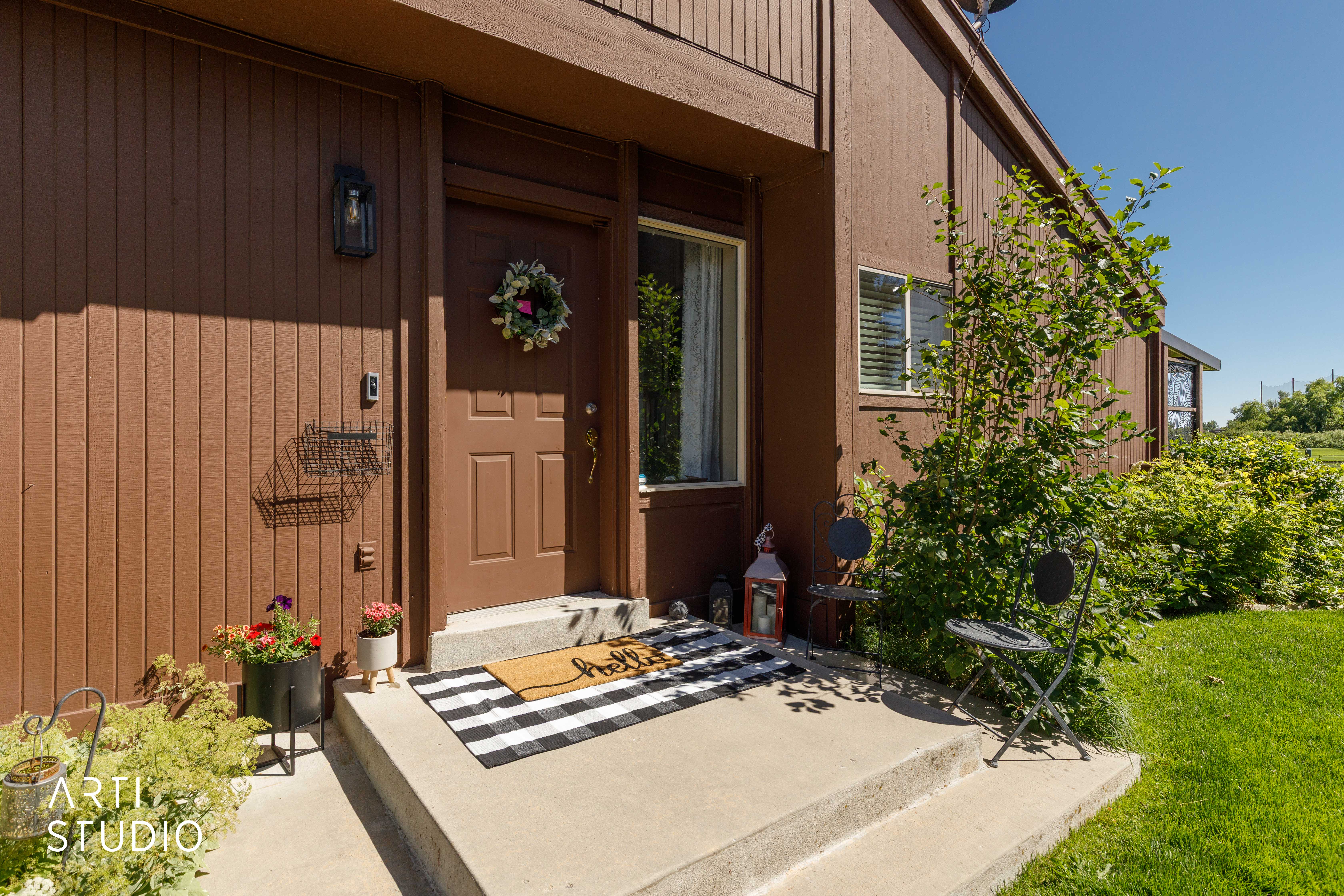 Brown vertical siding exterior with a concrete front porch and steps