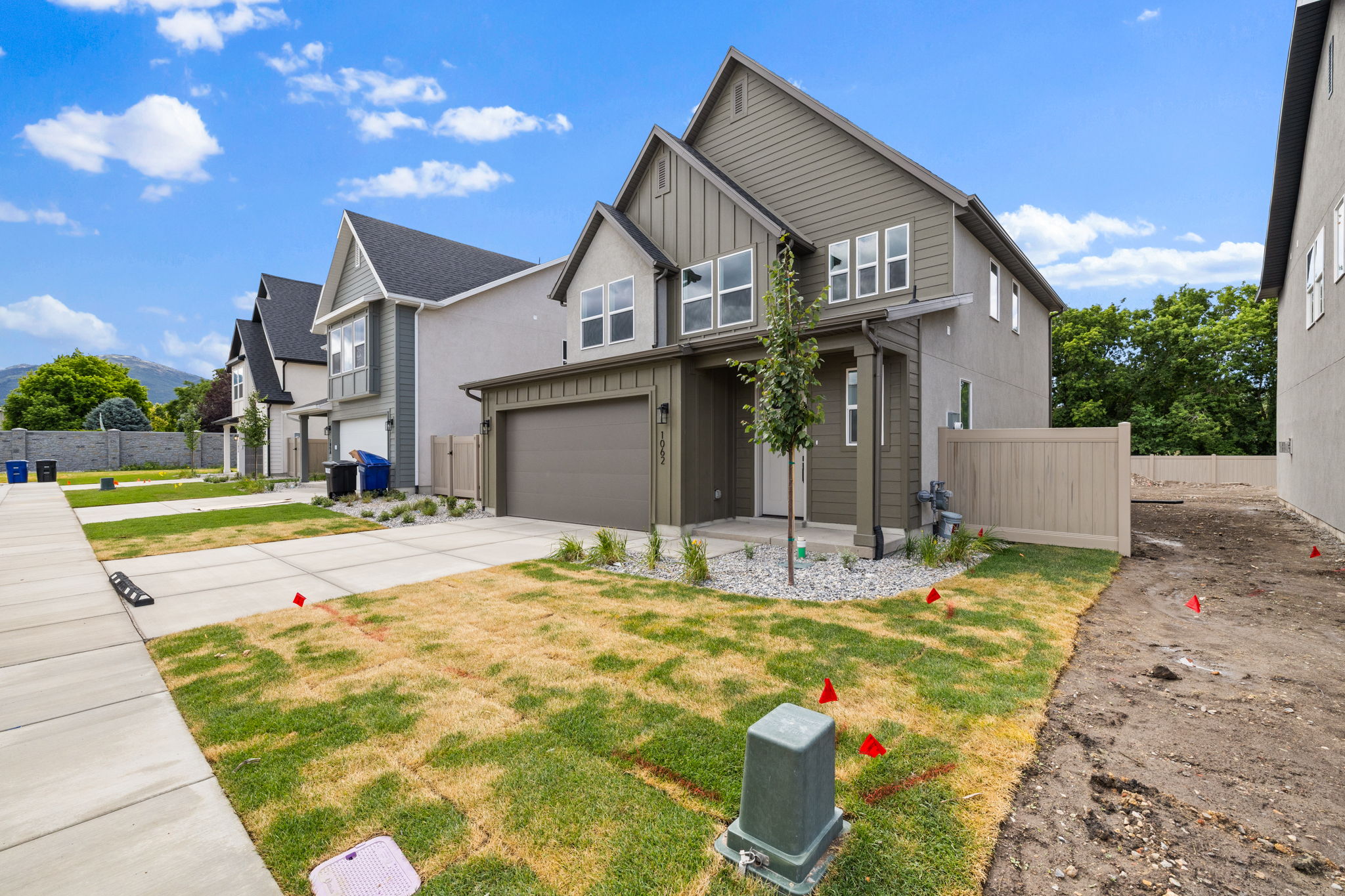Contemporary two-story residence featuring a two-car garage, board and batten siding accents, and a covered porch entry