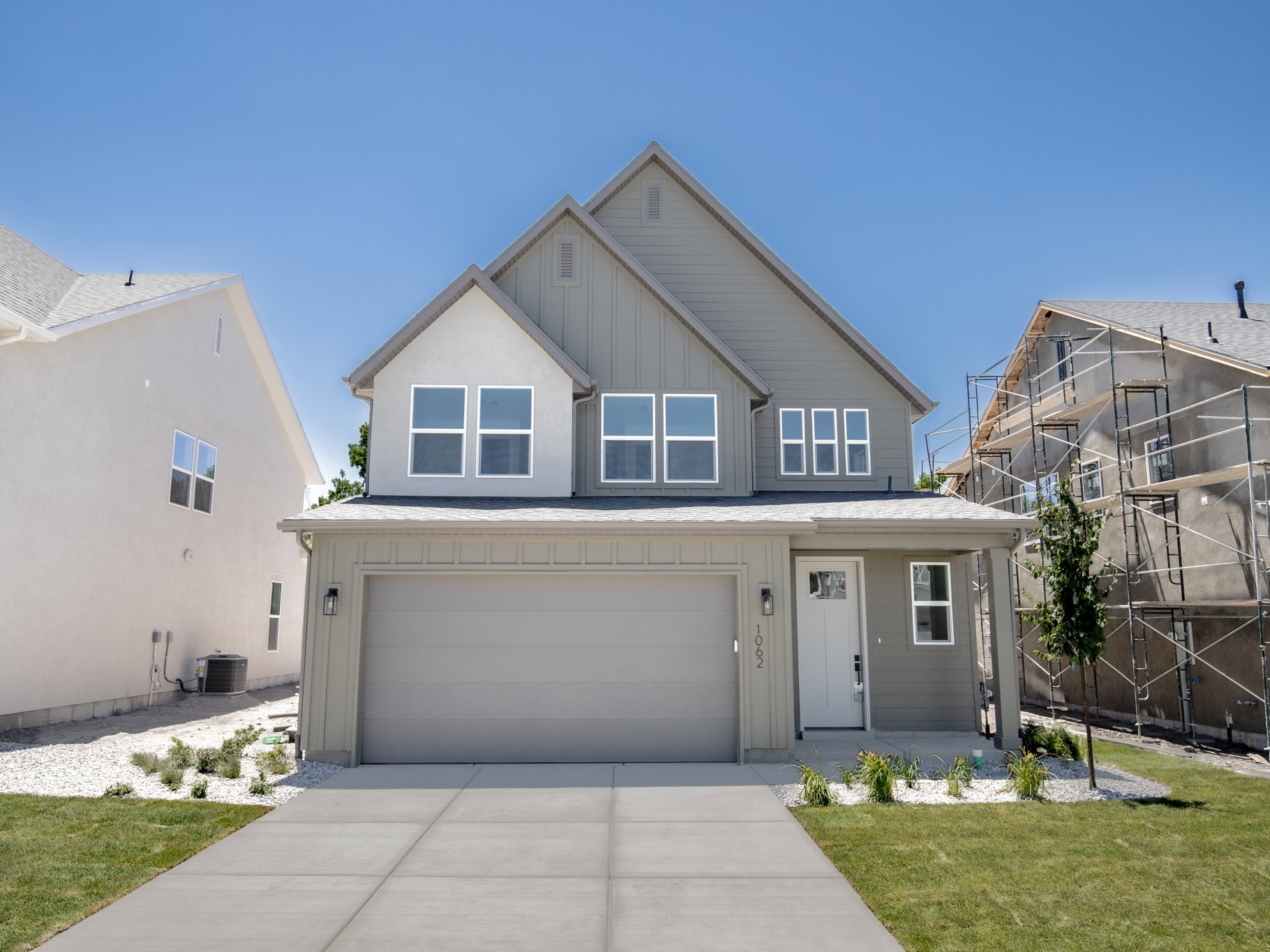 Modern two-story residence with a two-car garage, featuring a mixed-material facade of siding and stucco