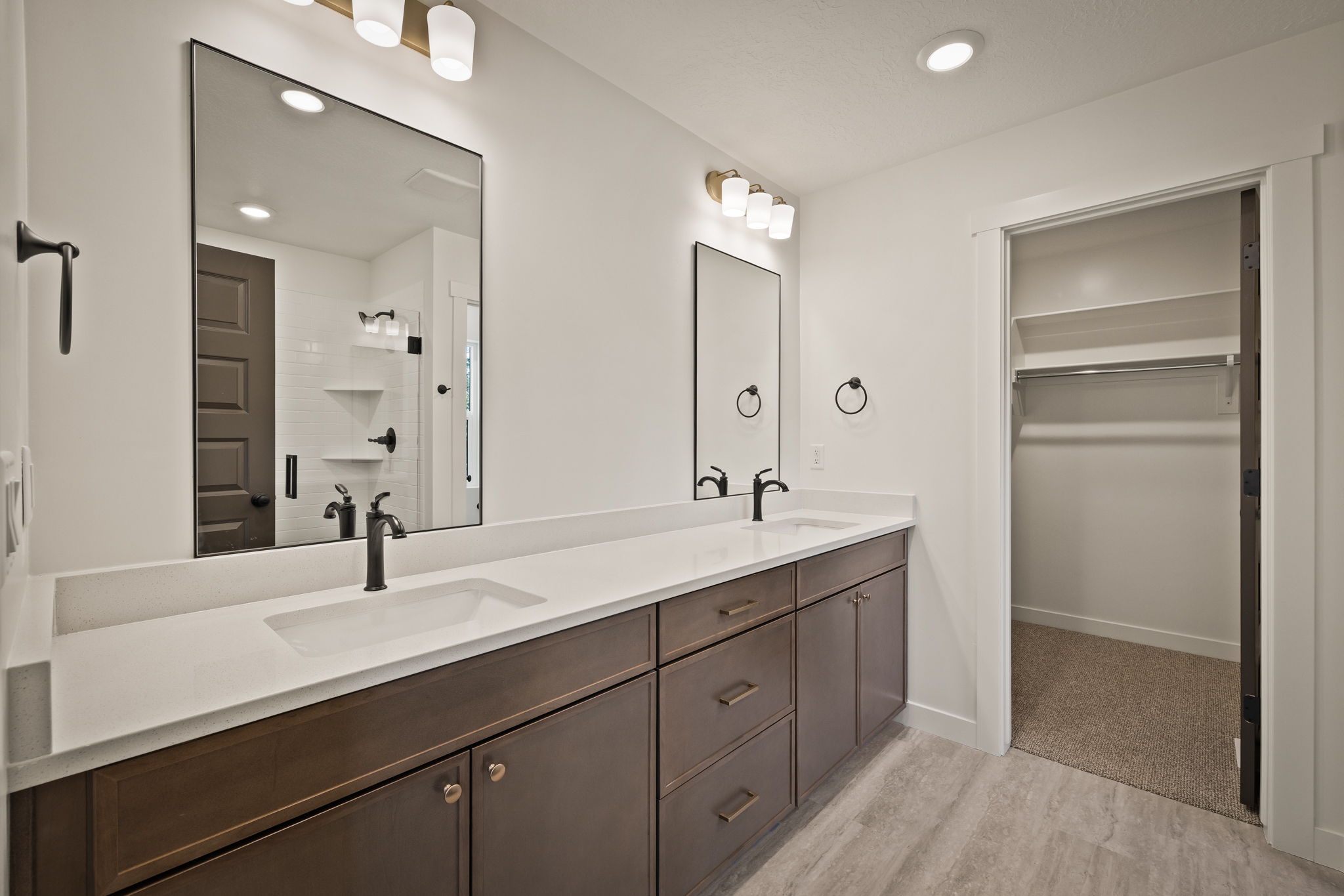 Dual vanity with integrated sinks, quartz-finish countertops, and dark-finish cabinetry