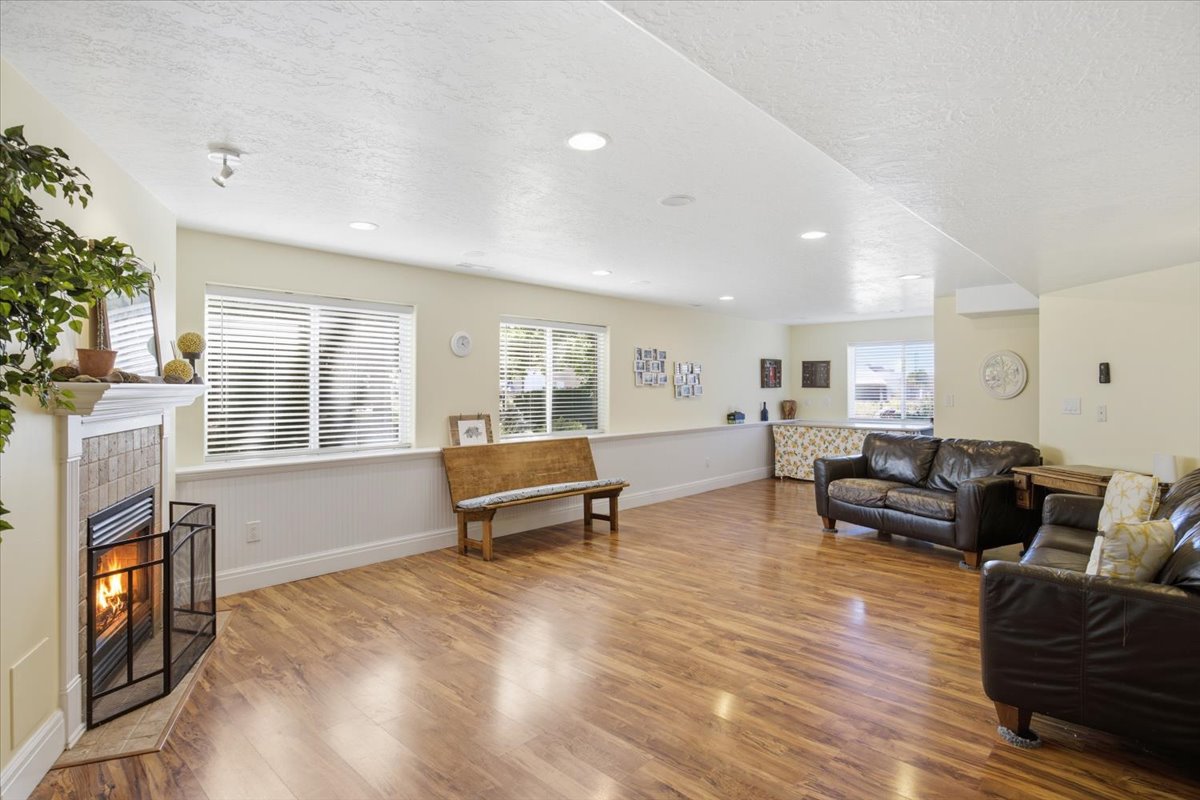 Spacious room featuring wood-finish flooring, recessed lighting, and ample natural light from multiple windows
