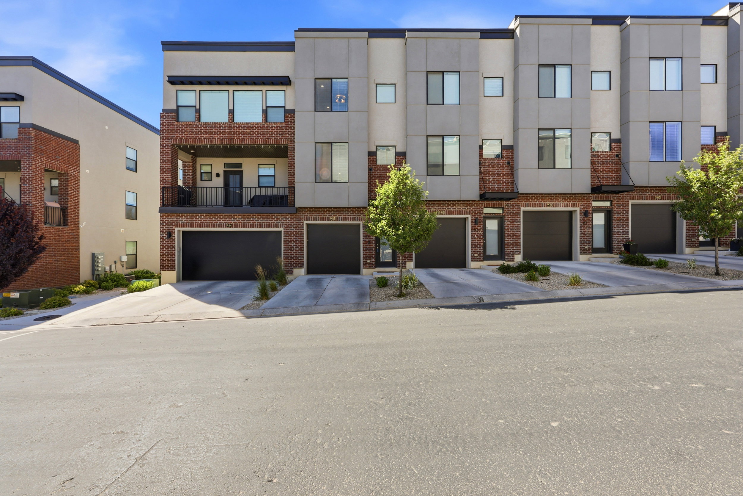 Contemporary townhouse exterior featuring brick and paneling accents