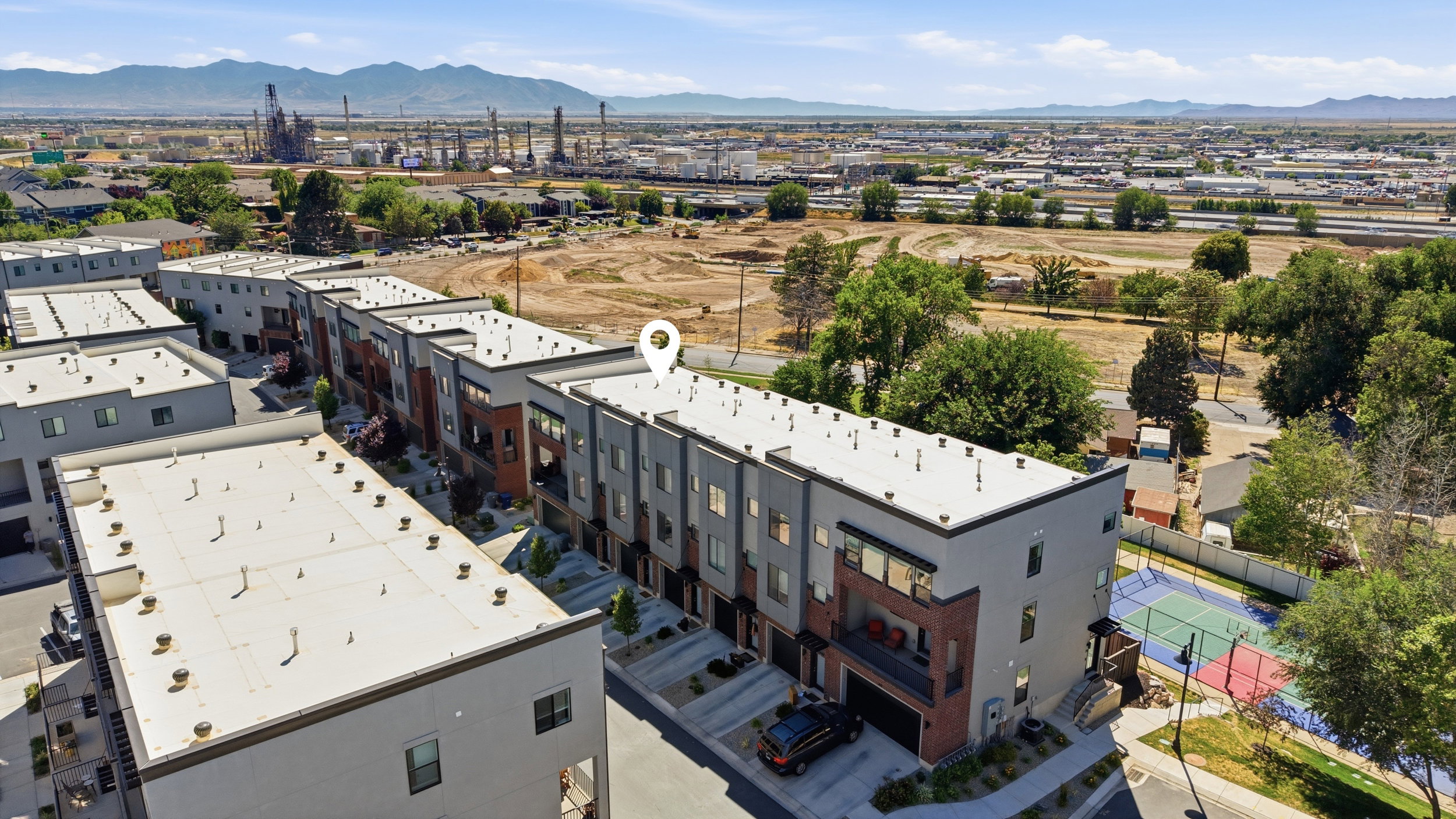 Modern townhome exterior with mixed material facade, integrated garage, and private balconies
