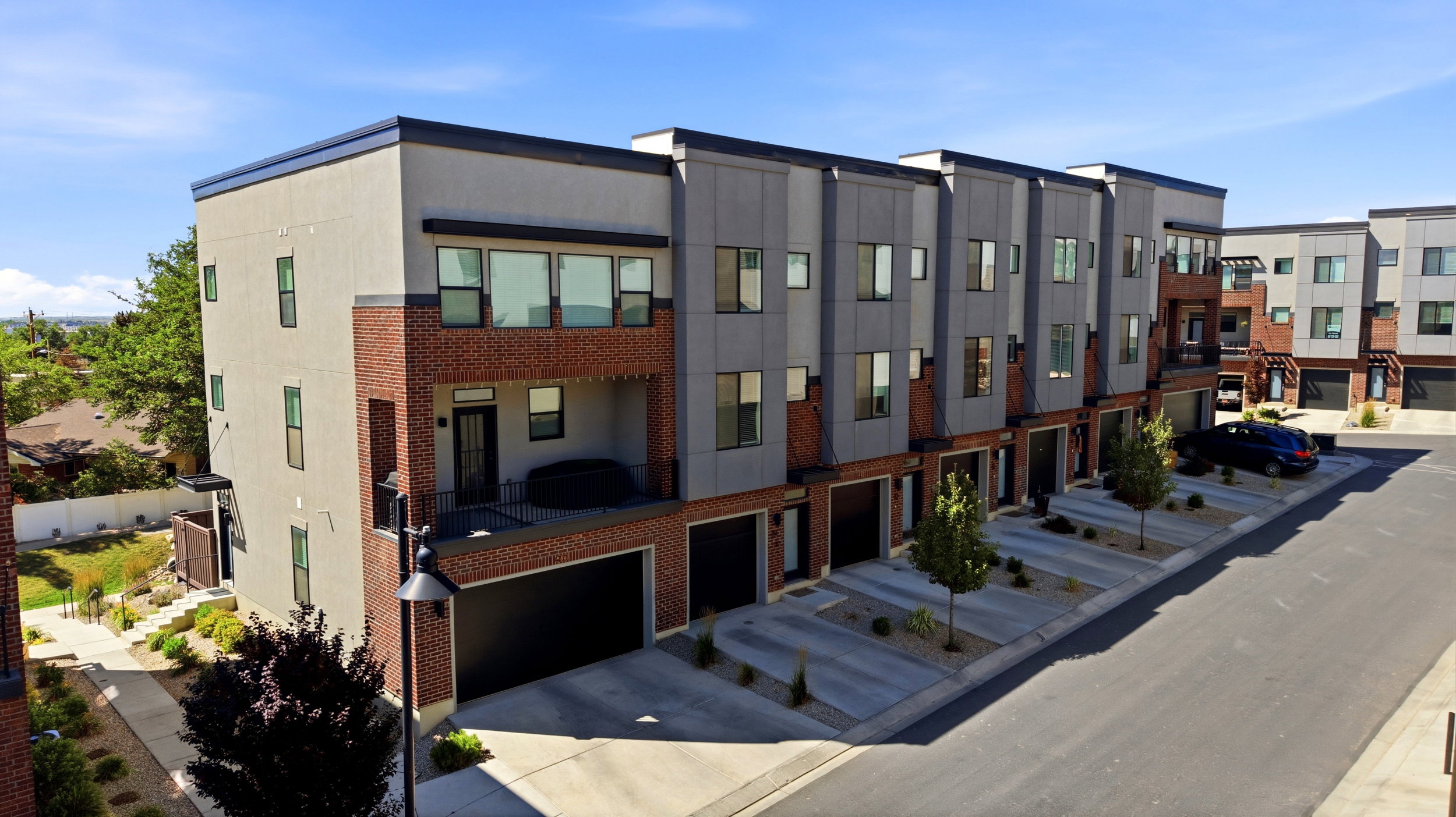 Modern multi-level townhome featuring a mix of brick and siding exteriors