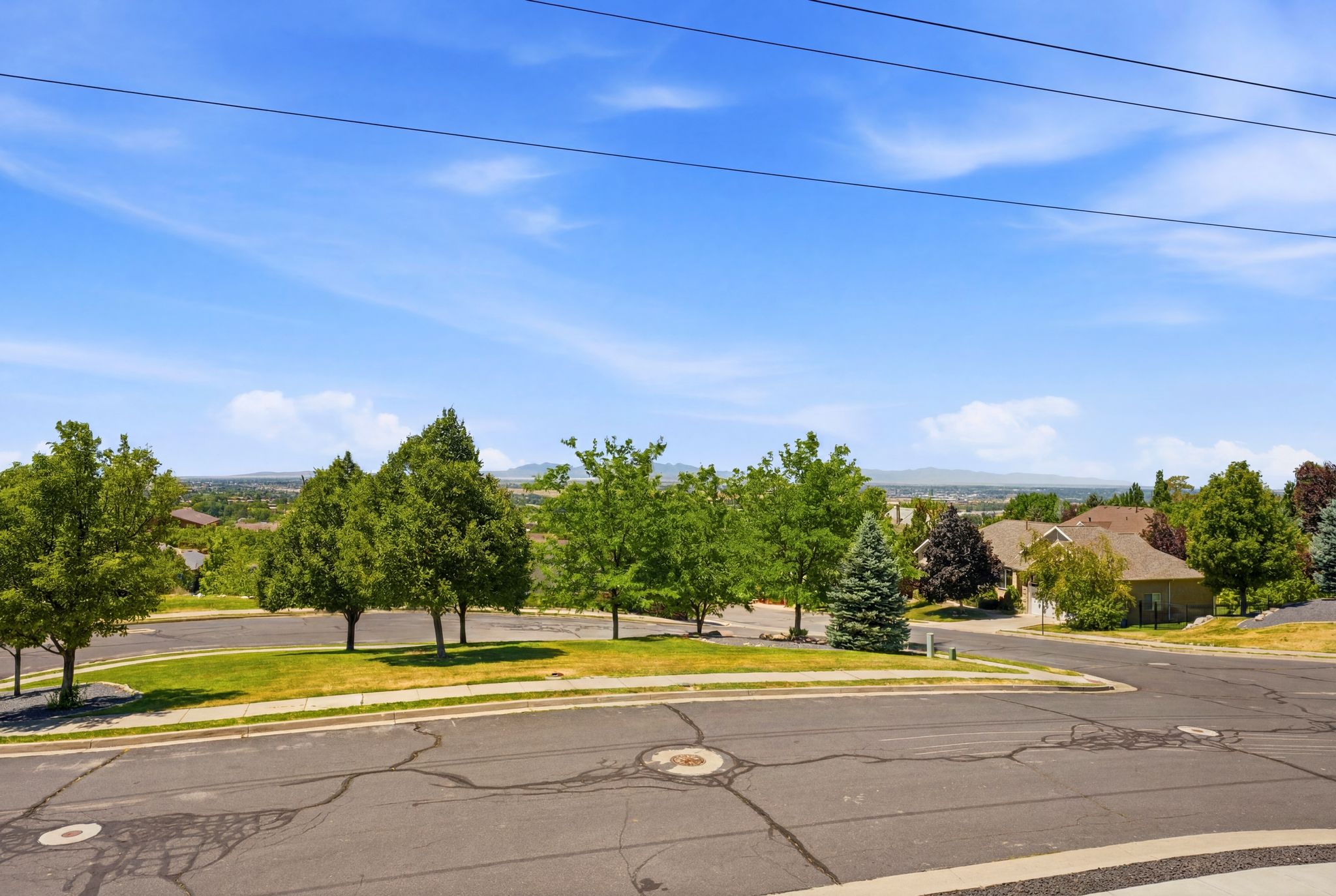 Neighborhood setting featuring mature trees and distant mountain range backdrop
